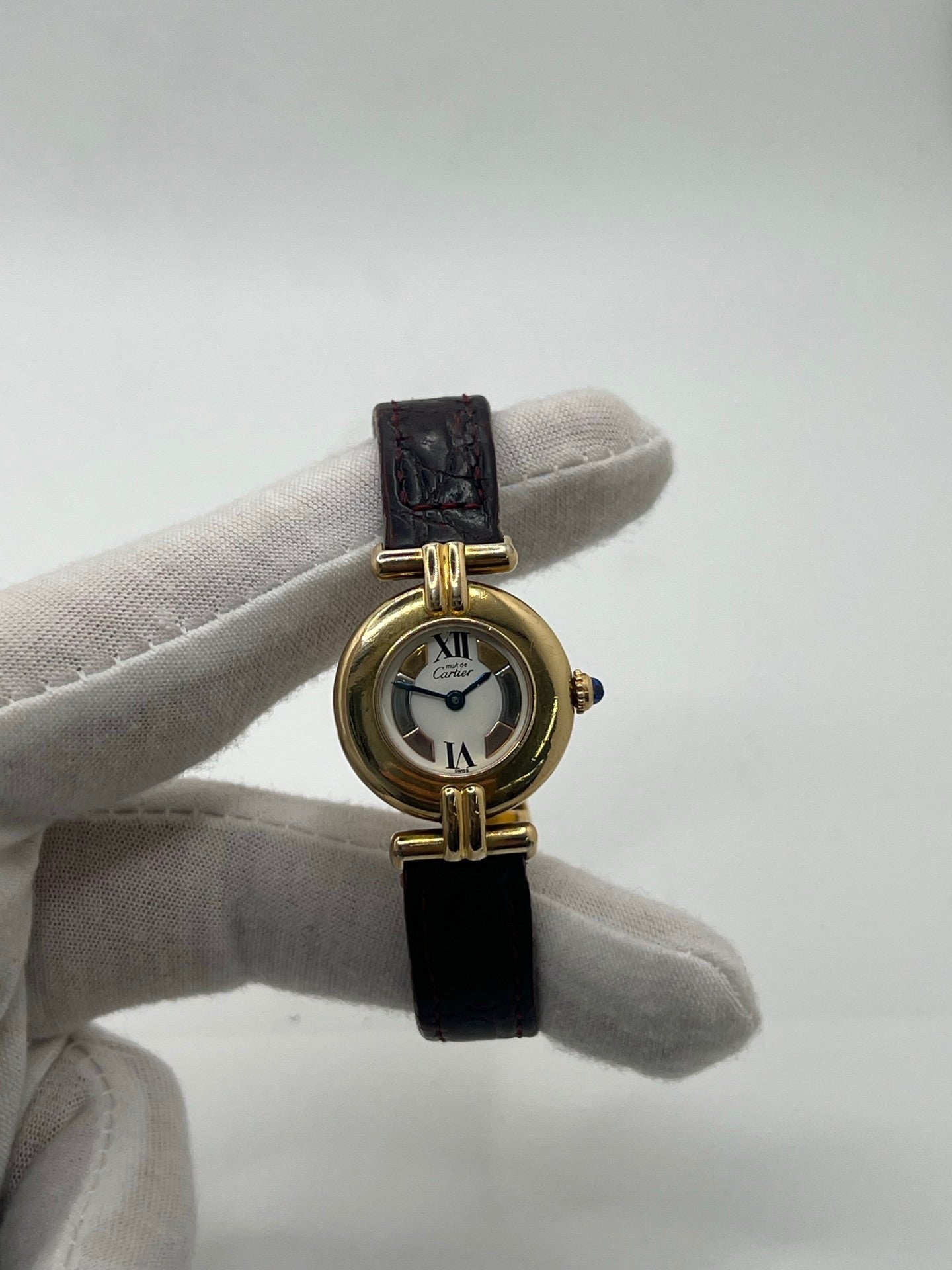 Montre femme Cartier Colisée réf. 590002 en argent avec mouvement quartz. Modèle vintage de 1995 au cadran blanc à chiffres romains et bracelet en cuir or. Verre saphir, boucle ardillon en argent. Élégance intemporelle signée Cartier, livrée avec coffret et papiers d’origine. Montre d’occasion en bon état, révisée en 2025.