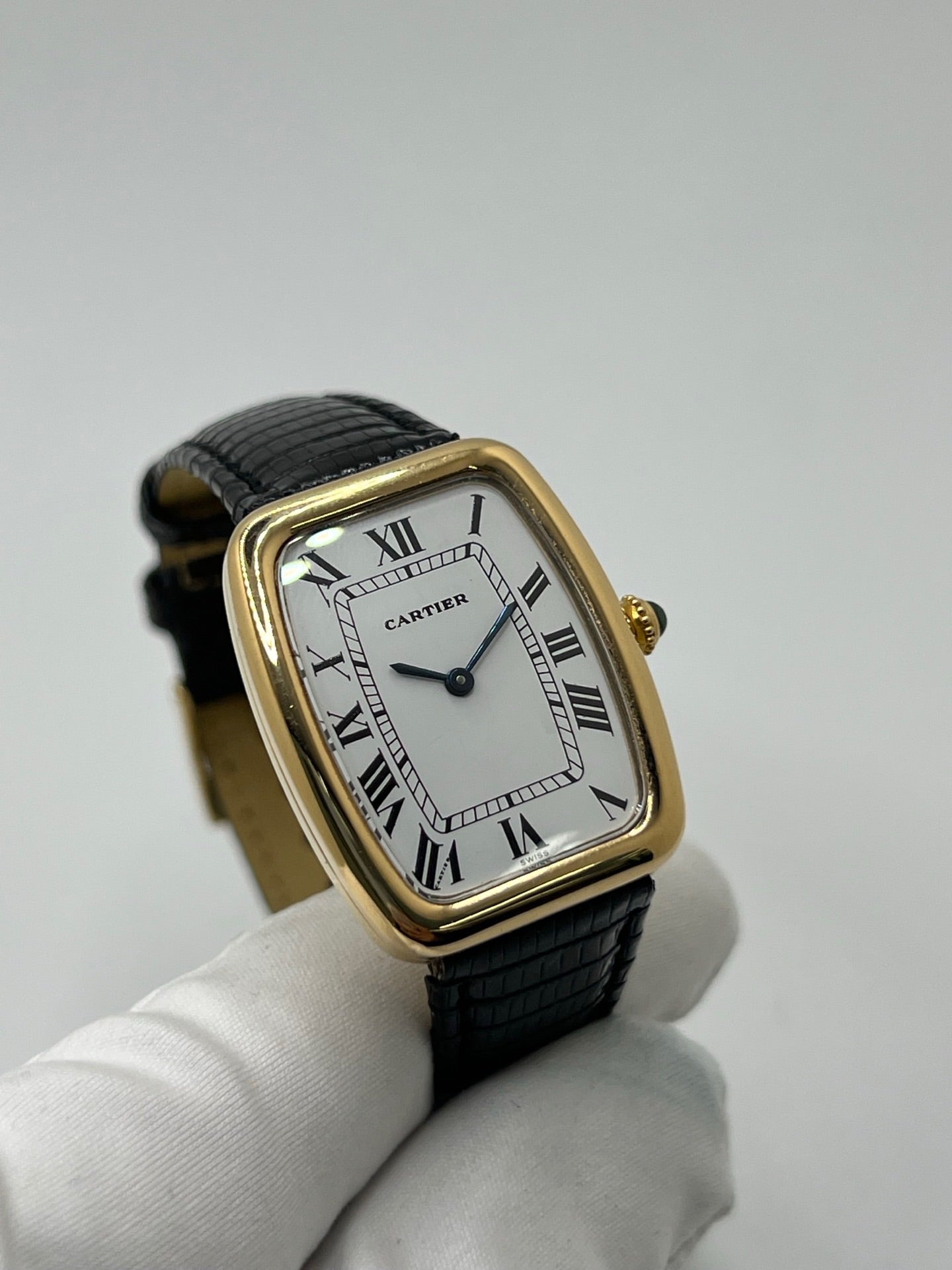 Montre Cartier Fabergé vintage en or jaune avec boîtier rectangulaire de 26 mm, cadran blanc à chiffres romains et bracelet en cuir noir. Ce modèle élégant à remontage manuel, fabriqué vers 1970, séduit par son style intemporel et raffiné. Montre homme ou unisexe d’occasion en très bon état, livrée avec coffret d’origine, idéale pour les amateurs d’horlogerie de luxe et de pièces vintage authentiques.