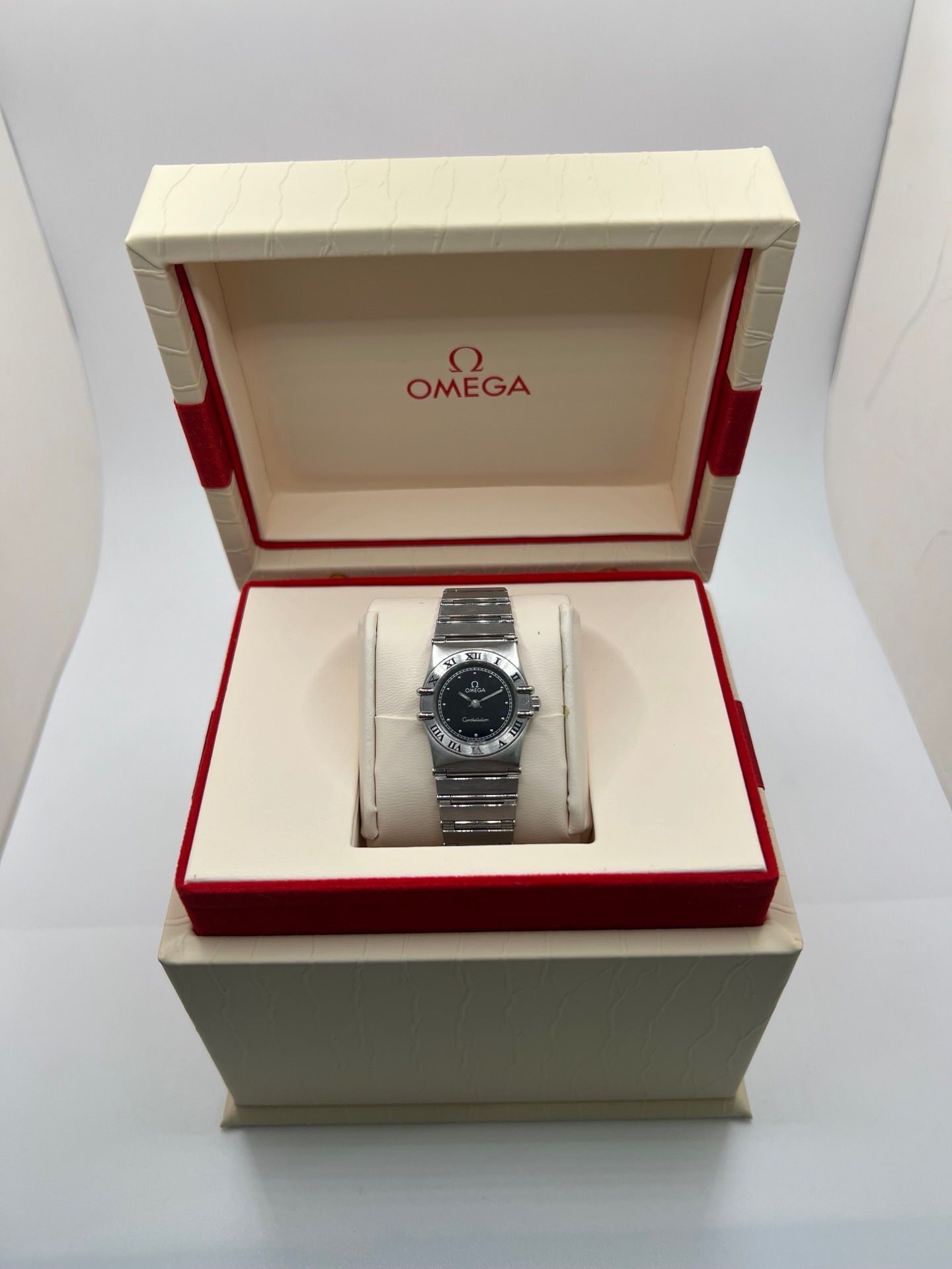 Montre femme Omega Constellation 795.1080 en acier avec cadran noir et chiffres romains. Mouvement quartz fiable, bracelet bicolore Or/Acier avec boucle pli. Diamètre 22 mm, verre saphir. État très bon, légère usure discrète. Coffret d’origine inclus, sans papiers. Parfaite pour élégance quotidienne et collection horlogère.