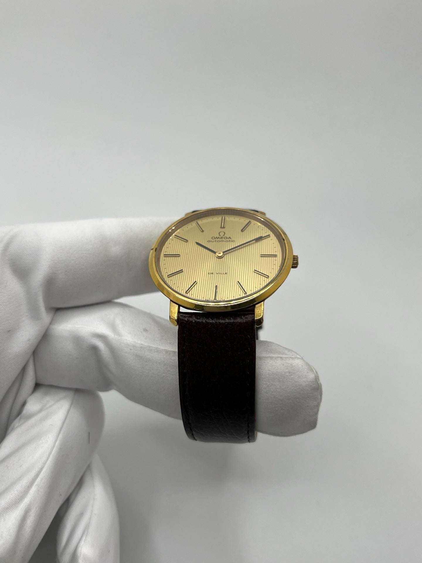 Montre Omega De Ville référence 151.0039 vintage de 1973 en acier avec mouvement automatique calibre 711, cadran doré et bracelet en cuir noir. Ce modèle homme ou unisexe de 35,5 mm présente un design élégant et intemporel. Montre d’occasion en très bon état, révisée en interne le 13 mars 2026, avec légères traces d’usure discrètes. Pièce classique de collection sans coffret ni papiers d’origine.