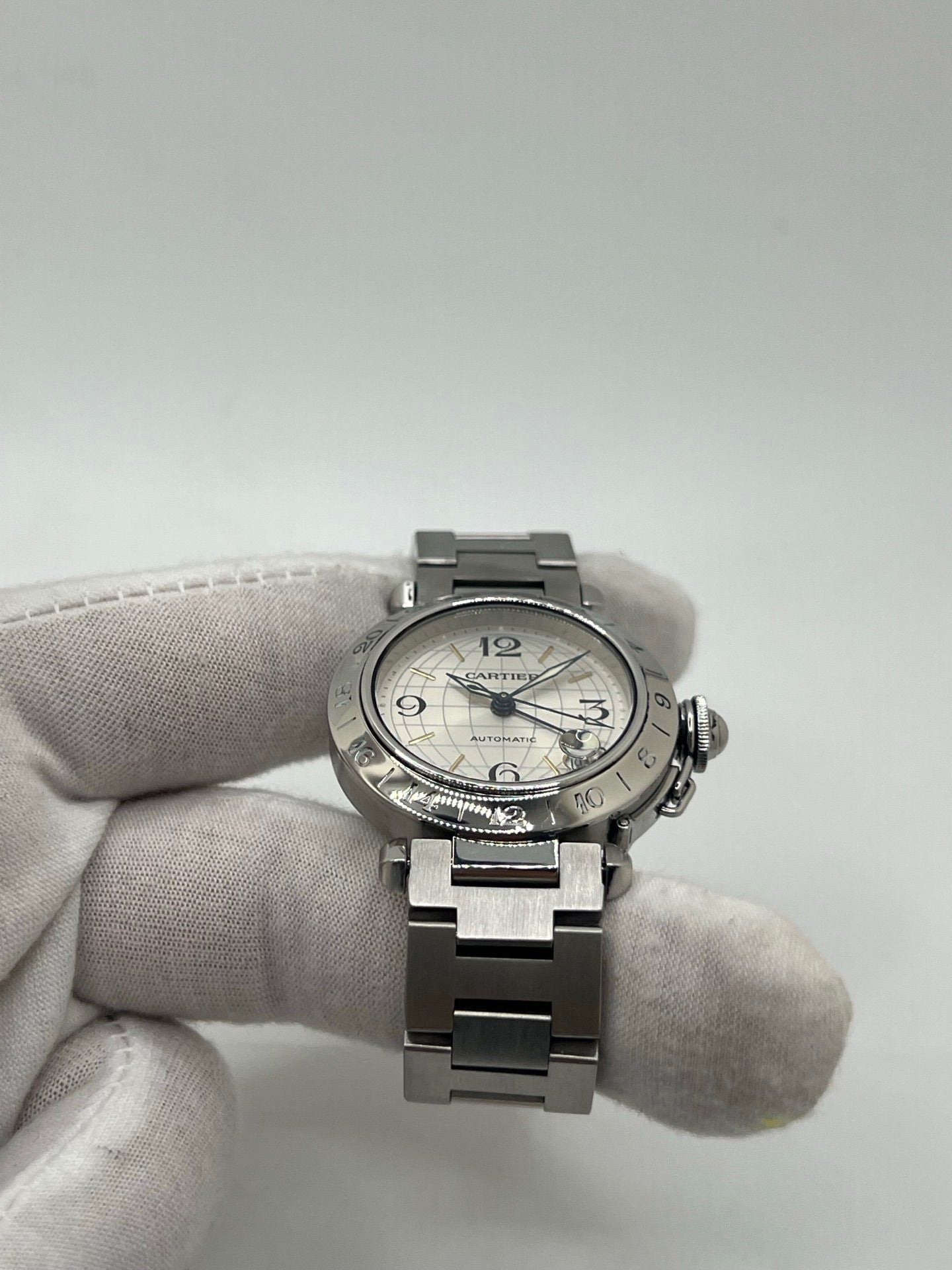 Montre Cartier Pasha C GMT réf. 2377 en acier, dotée d’un mouvement automatique calibre 048. Son boîtier de 35 mm abrite un cadran argenté à chiffres arabes, protégé par un verre saphir. Étanche jusqu’à 10 ATM, cette montre élégante et fonctionnelle est équipée d’un bracelet en acier et d’une boucle déployante double plis.