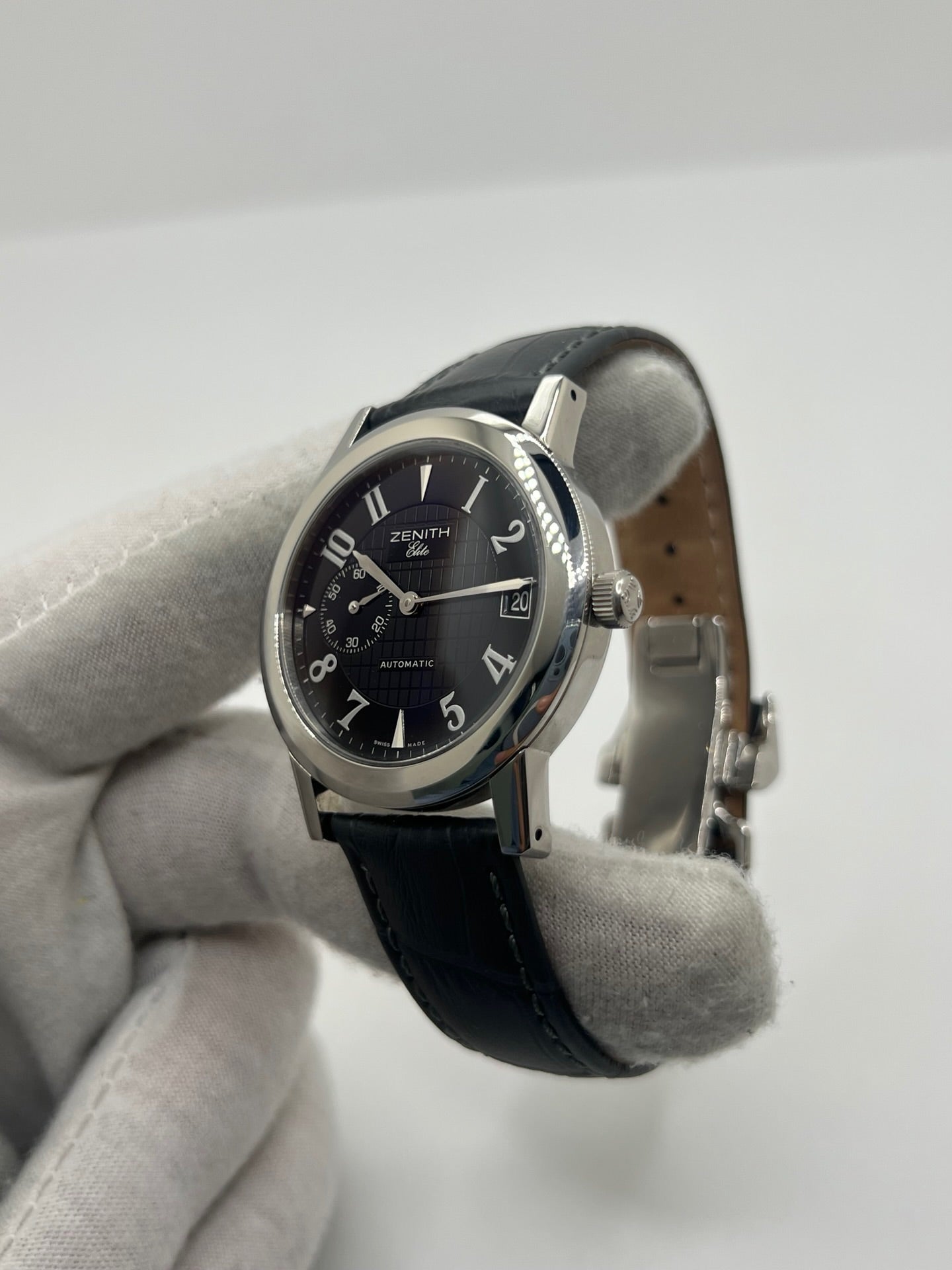 Montre Zenith Port Royal automatique en acier, modèle homme ou unisexe de 2007, équipée d’un boîtier de 37 mm et d’un élégant cadran noir à chiffres arabes. Cette montre d’occasion en très bon état dispose d’un verre saphir, d’une fonction date et d’une petite seconde. Son bracelet en cuir noir avec boucle ardillon souligne son style raffiné. Une montre Zenith Port Royal de luxe au design intemporel, idéale pour les passionnés d’horlogerie et les amateurs de pièces élégantes.