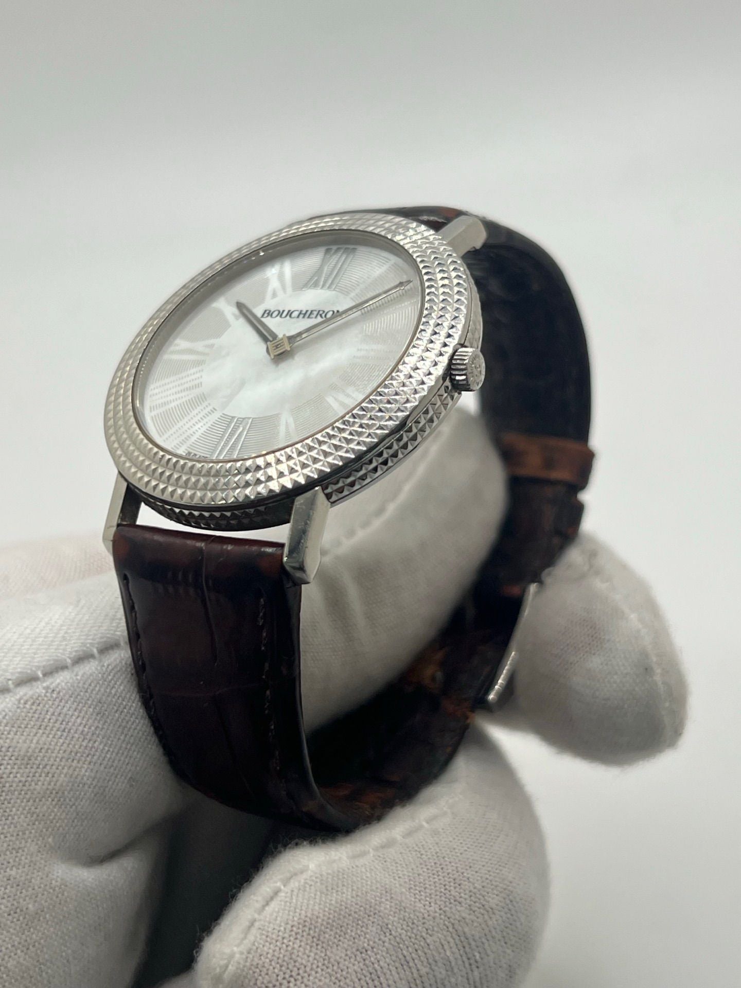 Découvrez l’élégance intemporelle de la Boucheron Ronde Clous de Paris, une montre Boucheron haut de gamme alliant raffinement et savoir-faire horloger. Ce modèle Ronde Clous de Paris se distingue par son cadran en nacre, subtilement mis en valeur par un boîtier en acier de 38 mm et un bracelet en peau d’alligator brun, synonyme de luxe et de confort.