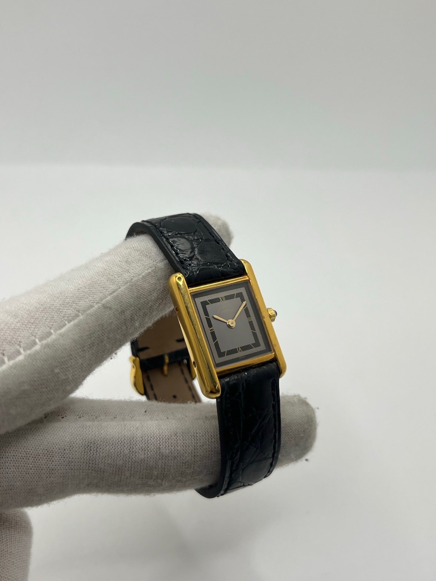 Montre Cartier Tank Vermeil 3 66001 pour femme, équipée d’un mouvement quartz et d’un boîtier en argent de 20 x 27 mm. Ce modèle d’occasion en très bon état présente un cadran or à chiffres romains, un verre minéral et un bracelet en cuir de crocodile noir avec boucle en acier. Élégante et intemporelle, la Cartier Tank Vermeil 3 66001 séduit par son design classique, idéale pour les passionnées de montres de luxe raffinées.