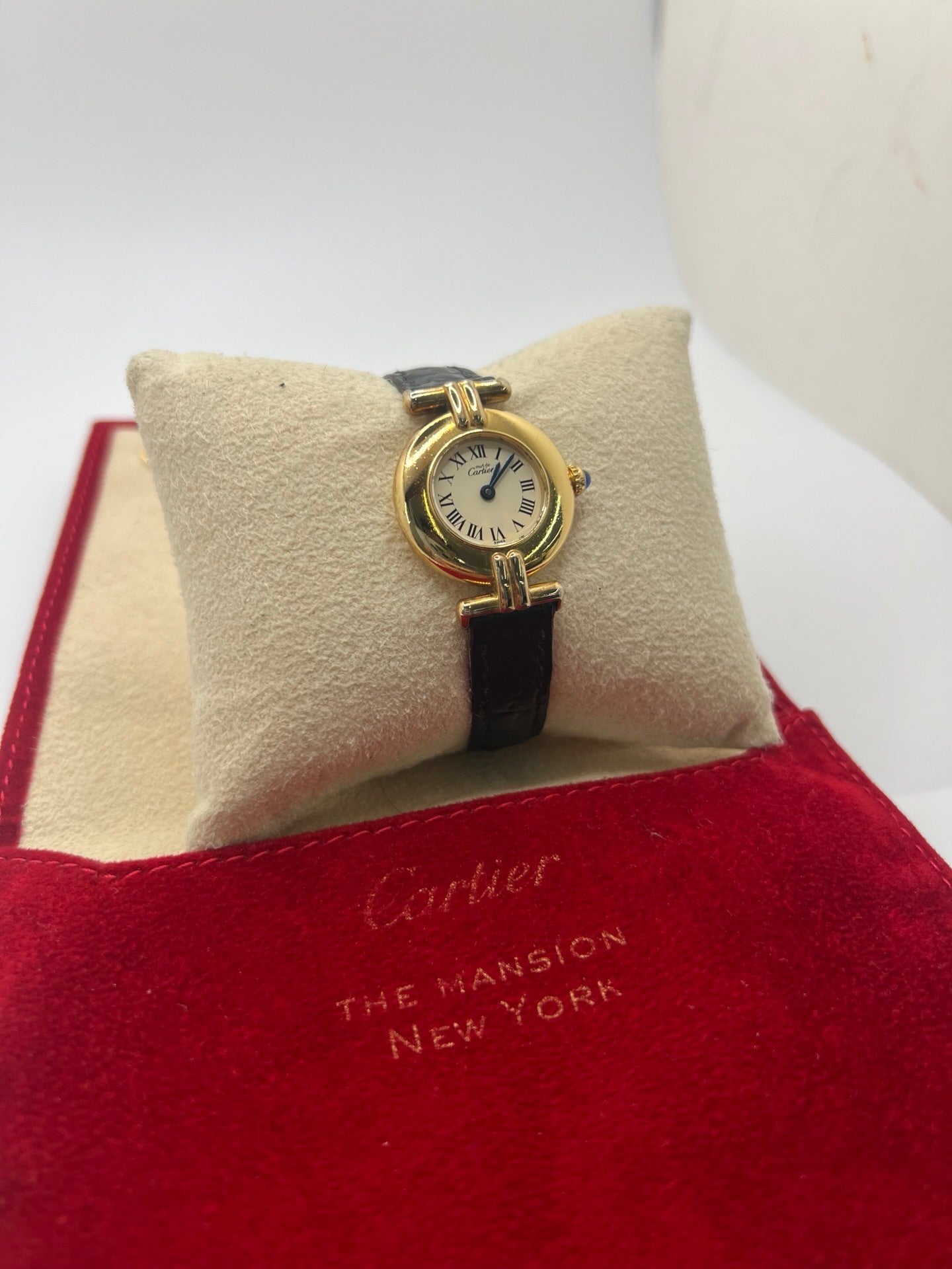Montre Cartier Colisée Must Vermeil réf. 590002 pour femme, équipée d’un mouvement quartz précis. Boîtier en argent vermeil de 24 mm, cadran blanc à chiffres romains, verre saphir et bracelet en cuir noir avec boucle ardillon. Modèle d’occasion en bon état présentant quelques traces d’usure. Idéal pour les amateurs de montres élégantes et intemporelles.