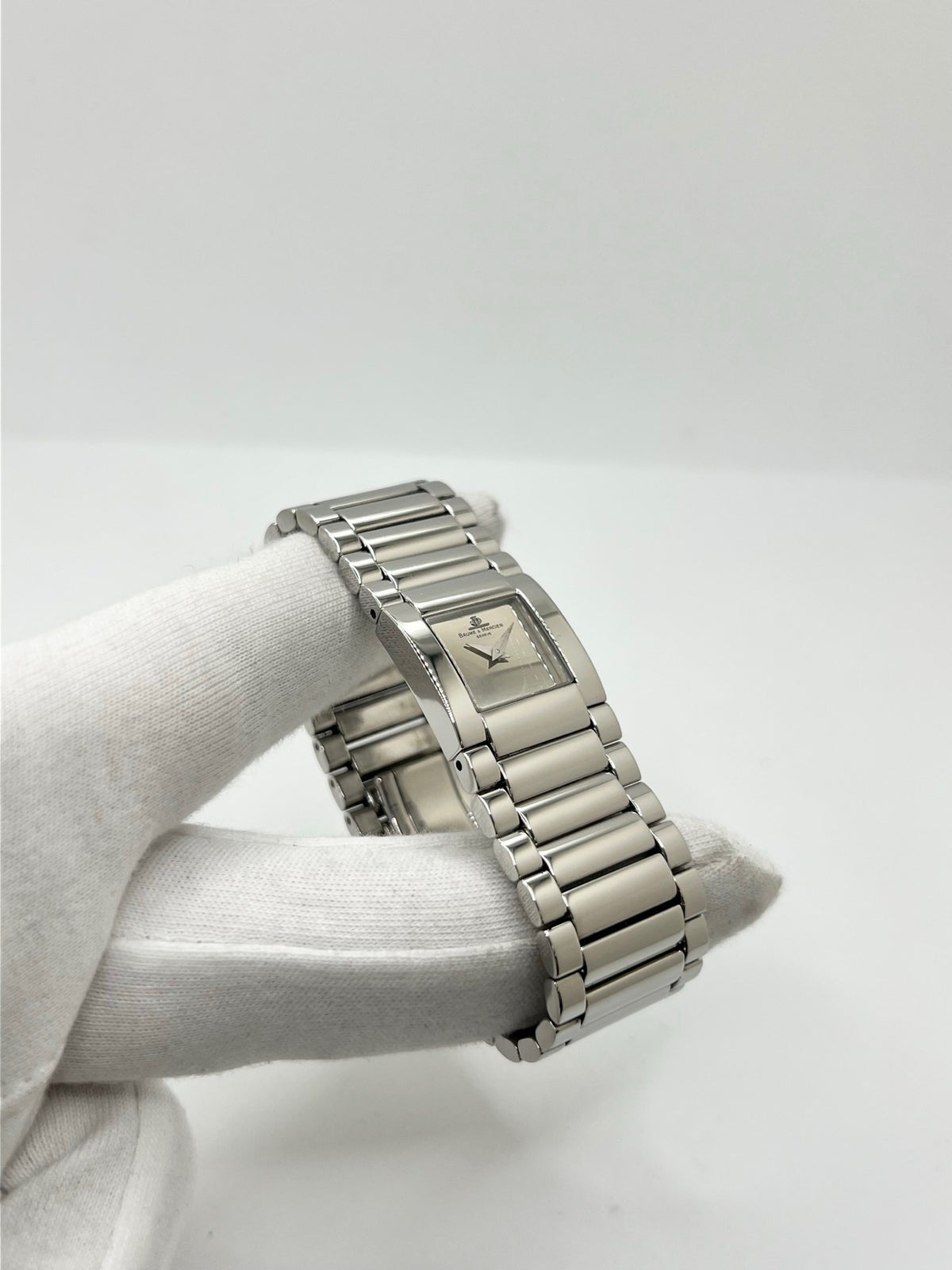 Montre femme Baume & Mercier Catwalk MV045219 à quartz, avec boîtier rectangulaire en acier de 24 x 21 mm, cadran argenté sans chiffres et bracelet en acier à boucle déployante double plis. Son verre saphir et son design élégant en font une montre raffinée et intemporelle. Cette Baume & Mercier Catwalk d’occasion est en très bon état, avec de légères rayures non perceptibles au toucher. Révisée en interne le 21 octobre 2026, elle est disponible à Paris sans coffret ni papiers d’origine.