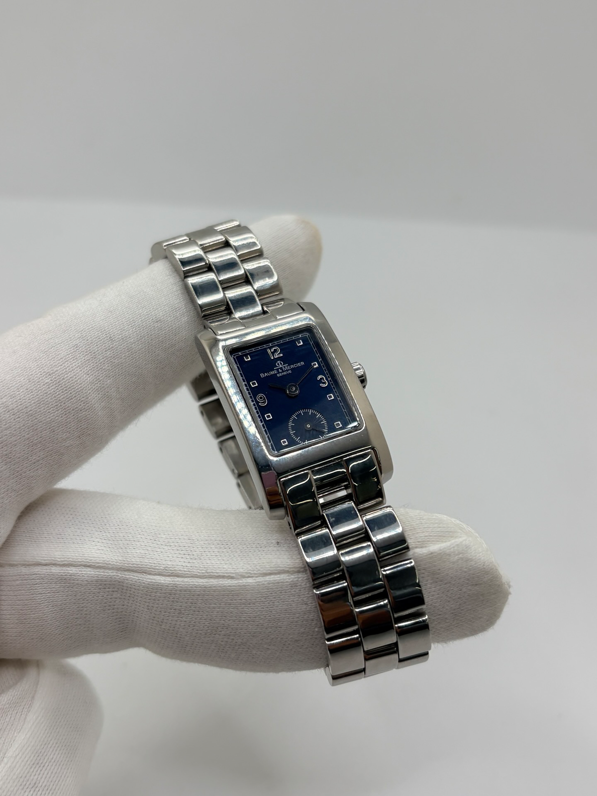 Montre Baume & Mercier Hampton MV045139 équipée d’un mouvement à quartz et d’un boîtier rectangulaire en acier de 20 × 34 mm. Son cadran bleu à chiffres arabes est protégé par un verre saphir. Cette montre Baume & Mercier Hampton est montée sur un bracelet en acier avec boucle déployante double plis. Élégante et contemporaine, elle séduit par ses lignes raffinées et son format rectangulaire emblématique, idéale pour un style chic au quotidien.