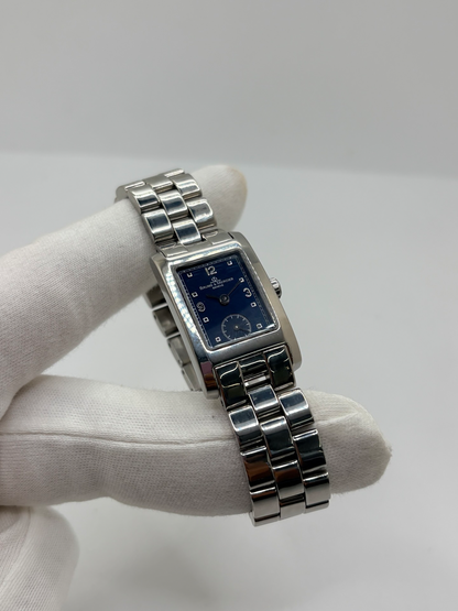 Montre Baume & Mercier Hampton MV045139 équipée d’un mouvement à quartz et d’un boîtier rectangulaire en acier de 20 × 34 mm. Son cadran bleu à chiffres arabes est protégé par un verre saphir. Cette montre Baume & Mercier Hampton est montée sur un bracelet en acier avec boucle déployante double plis. Élégante et contemporaine, elle séduit par ses lignes raffinées et son format rectangulaire emblématique, idéale pour un style chic au quotidien.