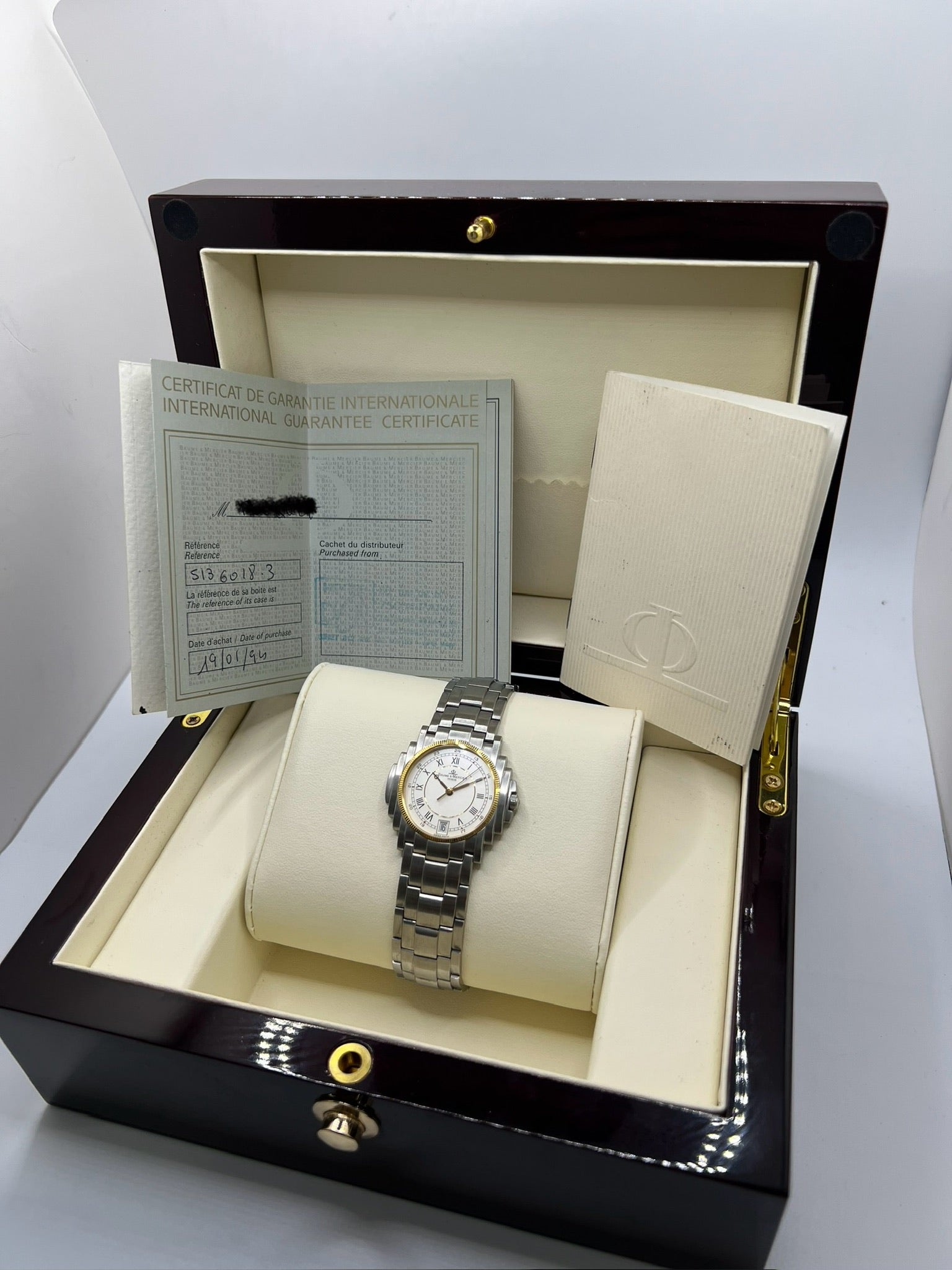 Montre Baume & Mercier 5136.018.3 pour homme/unisexe, boîtier 34 mm en or et acier, cadran blanc à chiffres romains, mouvement quartz précis. Verre saphir résistant aux rayures, bracelet en acier avec boucle double plis. Fonction date. Montre d’occasion en très bon état avec papiers d’origine, élégante et intemporelle.