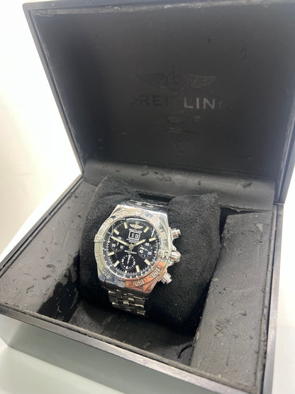 Breitling Blackbird référence A44359, chronographe automatique pour homme avec boîtier en acier de 44 mm et bracelet acier assorti. Cadran noir sans chiffres offrant une lecture claire, protégé par un verre saphir résistant aux rayures. Lunette acier et étanchéité jusqu’à 30 ATM. Équipée du calibre Breitling 44 avec réserve de marche d’environ 42 heures, fonction chronographe et date. Modèle de 2010 en très bon état, révisé, livré avec coffret et papiers d’origine.