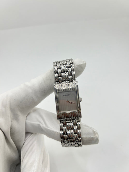 Montre Boucheron Reflet en acier avec mouvement quartz, dotée d’un élégant cadran argent massif sans chiffres et protégée par un verre saphir. Son boîtier rectangulaire de 21 x 32 mm et son bracelet en acier avec boucle double pliant lui confèrent un style raffiné et intemporel. Cette montre de luxe unisexe séduit par ses lignes épurées et son design emblématique, idéal pour les amateurs d’horlogerie et de pièces de prestige d’occasion.
