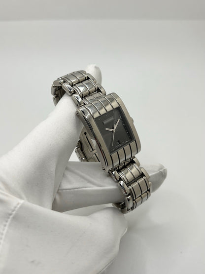 Montre Boucheron Reflet Icare Parallèle en acier, boîtier rectangulaire de 28 x 40 mm avec verre saphir et cadran gris à index bâtons. Équipée d’un mouvement quartz fiable et d’un bracelet en acier avec boucle double déployante. Fonction date discrète. Modèle élégant au design graphique emblématique de la collection Reflet. Montre d’occasion en très bon état, présentant de légères micro-rayures, révisée en interne, sans coffret ni papiers d’origine.