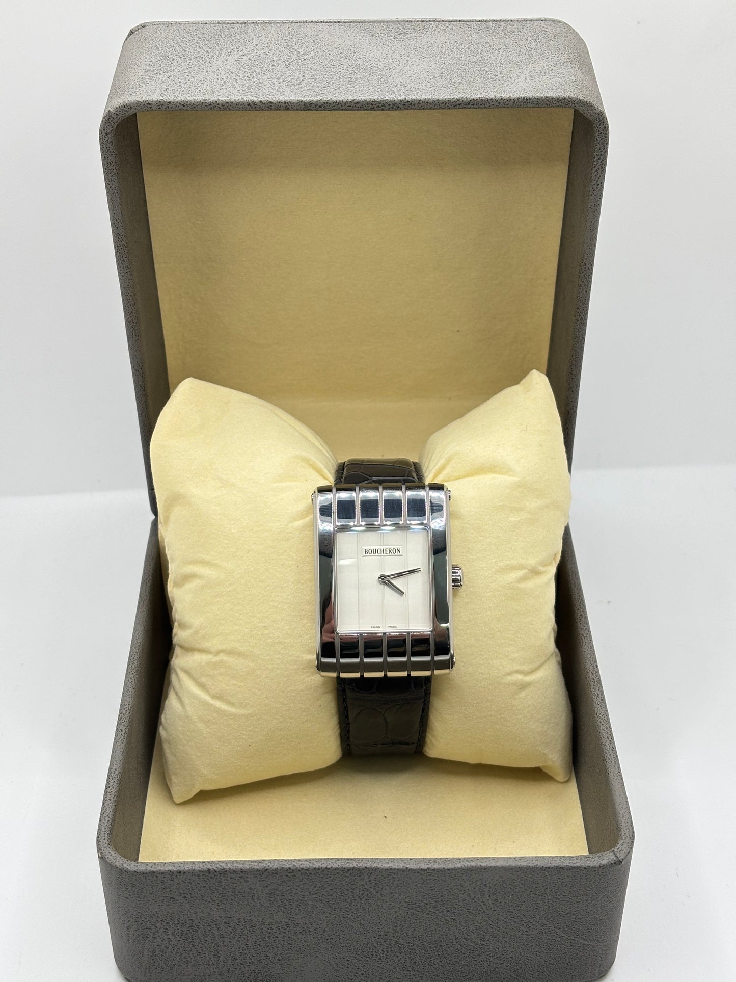 Montre Boucheron Reflet Icare Parallèle en acier, équipée d’un mouvement quartz précis. Boîtier rectangulaire 28 x 40 mm avec verre saphir et cadran blanc épuré. Bracelet en cuir de crocodile noir avec boucle ardillon en acier. Modèle homme/unisexe au design élégant et intemporel. Montre d’occasion en très bon état, présentant de légères traces d’usure non perceptibles au toucher, révisée en avril 2026, idéale pour amateurs d’horlogerie et de pièces de luxe.