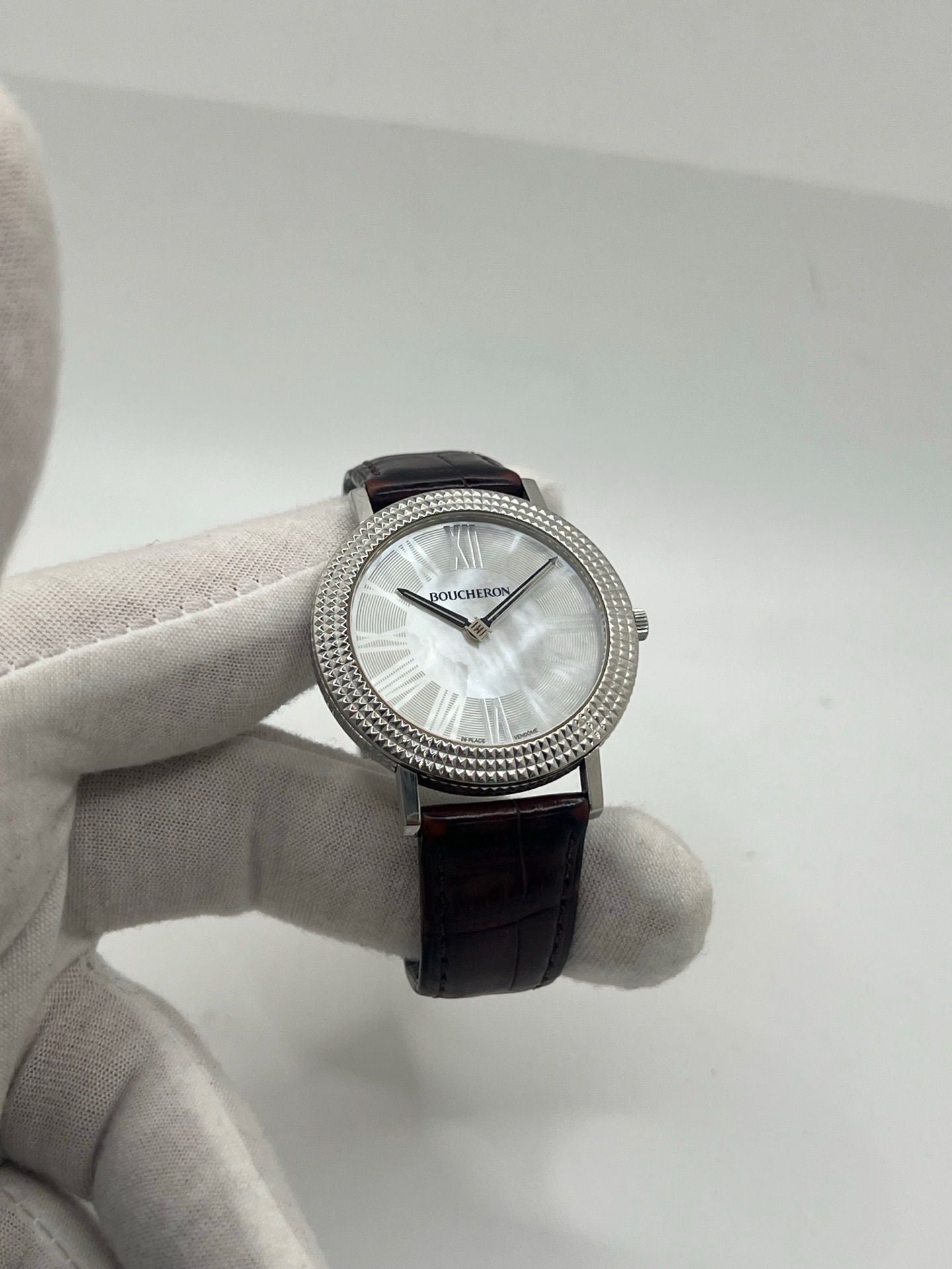 Découvrez l’élégance intemporelle de la Boucheron Ronde Clous de Paris, une montre Boucheron haut de gamme alliant raffinement et savoir-faire horloger. Ce modèle Ronde Clous de Paris se distingue par son cadran en nacre, subtilement mis en valeur par un boîtier en acier de 38 mm et un bracelet en peau d’alligator brun, synonyme de luxe et de confort.