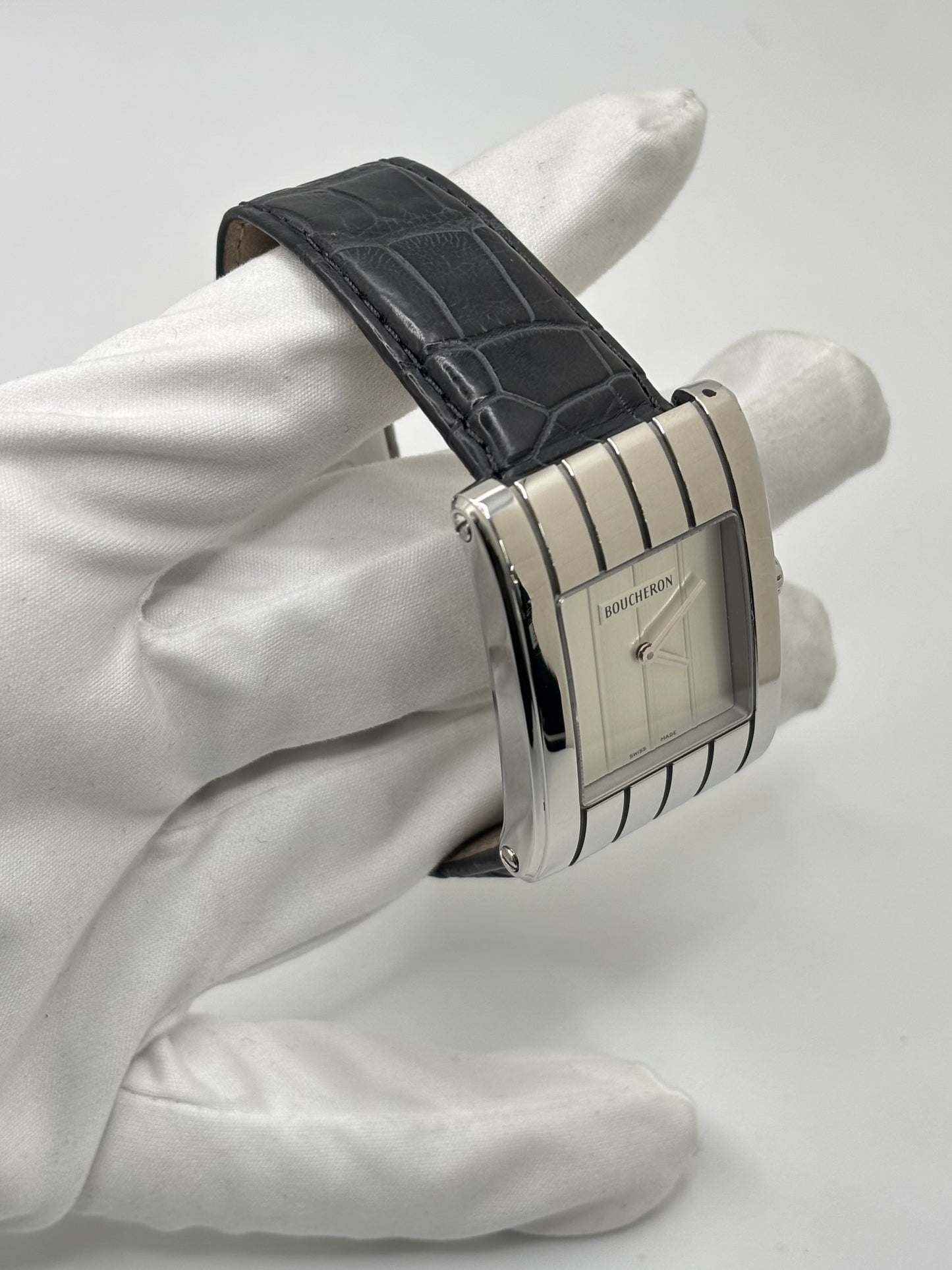 Montre Boucheron Reflet Icare Parallèle en acier, équipée d’un mouvement quartz précis. Boîtier rectangulaire 28 x 40 mm avec verre saphir et cadran blanc épuré. Bracelet en cuir de crocodile noir avec boucle ardillon en acier. Modèle homme/unisexe au design élégant et intemporel. Montre d’occasion en très bon état, présentant de légères traces d’usure non perceptibles au toucher, révisée en avril 2026, idéale pour amateurs d’horlogerie et de pièces de luxe.