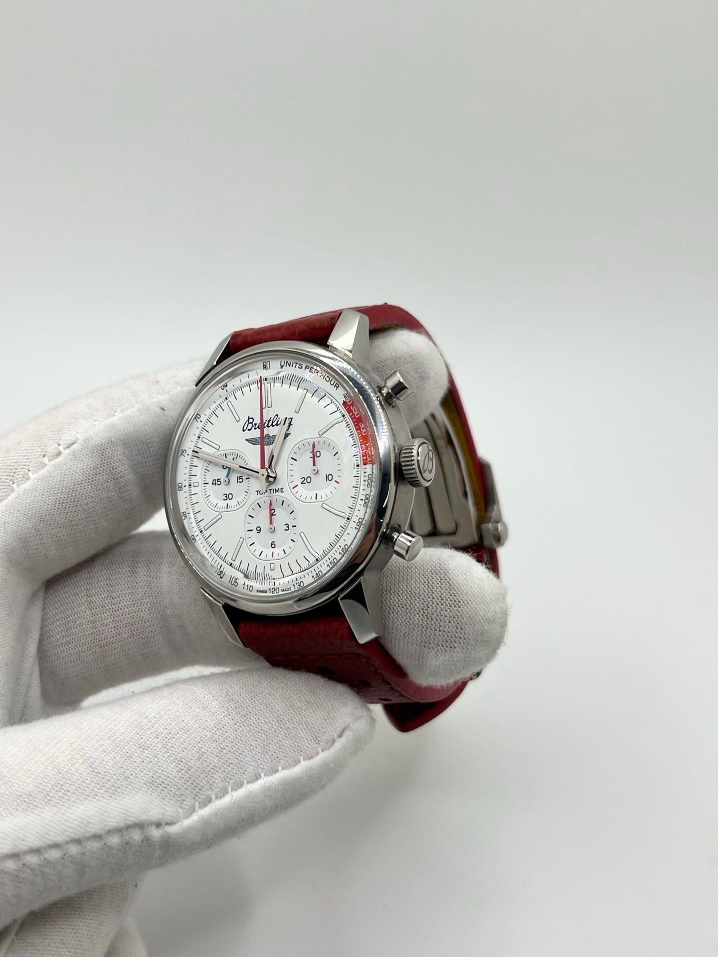 Montre chronographe automatique pour homme au design inspiré des années 60, dotée d’un boîtier en acier de 41 mm, d’un cadran blanc épuré sans chiffres et de compteurs contrastés. Mouvement automatique calibre 01 avec réserve de marche de 70 heures, verre saphir et étanchéité 10 ATM. Bracelet en cuir rouge avec boucle en acier, style sportif et vintage, montre mécanique suisse en très bon état avec coffret et papiers d’origine.