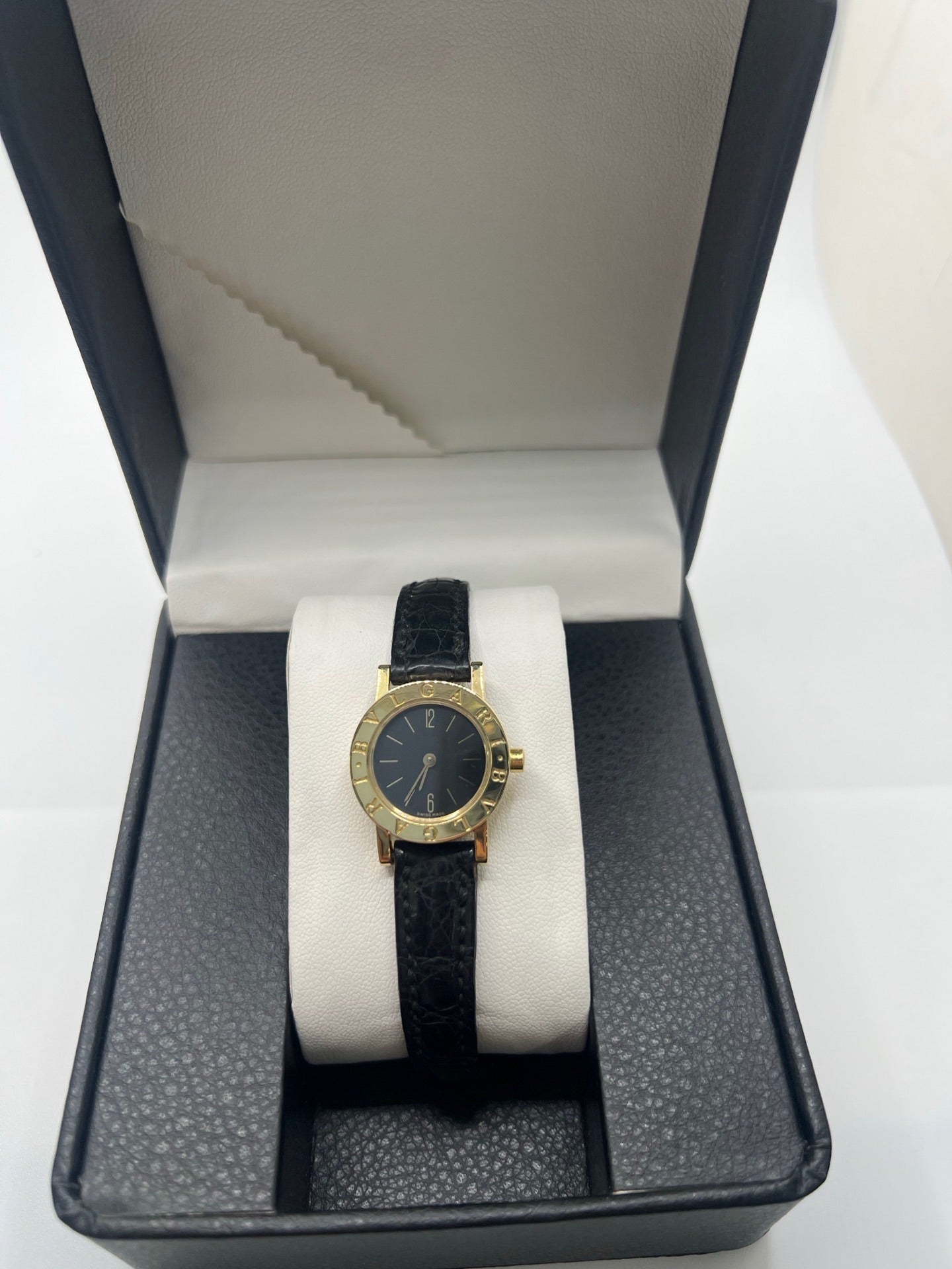 Montre femme Bulgari Bulgari Lady BB 23 GL en or jaune avec boîtier rond de 23 mm, cadran noir élégant et verre saphir. Cette montre de luxe à mouvement quartz est dotée d’un bracelet en cuir noir avec boucle ardillon en or jaune. Modèle emblématique au design intemporel, idéal pour un poignet féminin, alliant raffinement, précision et savoir-faire horloger italien. Parfaite comme montre habillée ou pièce de collection.