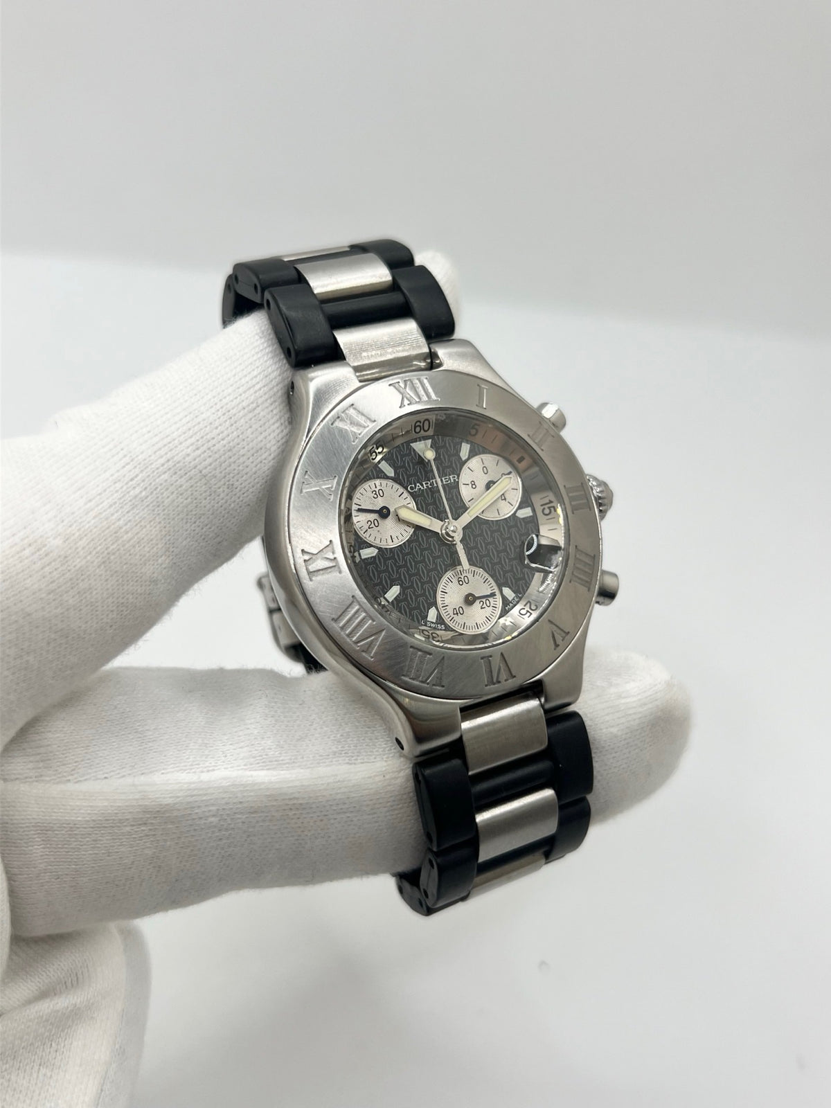 Montre Cartier 21 Chronoscaph 2424 à quartz, dotée d’un boîtier en acier de 38 mm et d’une épaisseur de 10 mm. Son cadran noir est protégé par un verre saphir et accompagné d’un bracelet en caoutchouc avec boucle déployante en acier. Étanche à 10 ATM, cette montre Cartier possède les fonctions chronographe et date. En très bon état, elle présente de légères traces d’usure et a été révisée en interne en septembre 2026.
