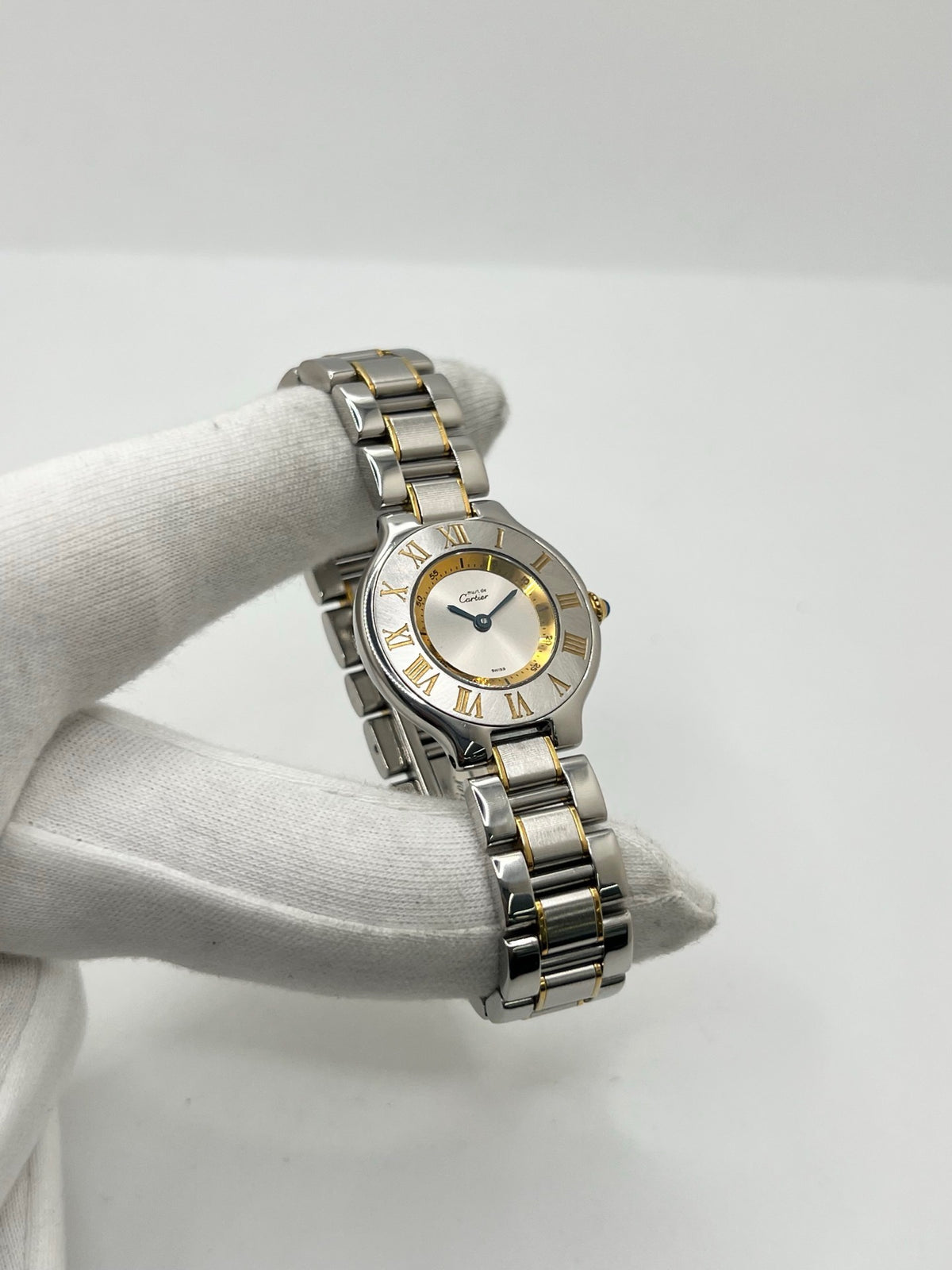 Montre Cartier 21 Must de Cartier référence 1340, modèle vintage au design intemporel. Cette montre de luxe présente un boîtier en acier de 28 mm, un bracelet bicolore en acier et or ainsi qu’un cadran argenté. Équipée d’un mouvement quartz suisse à 7 rubis et d’un verre saphir, elle offre une étanchéité de 3 ATM. Élégante et raffinée, cette Cartier 21 vintage allie le savoir-faire horloger de Cartier à un style classique et sophistiqué.