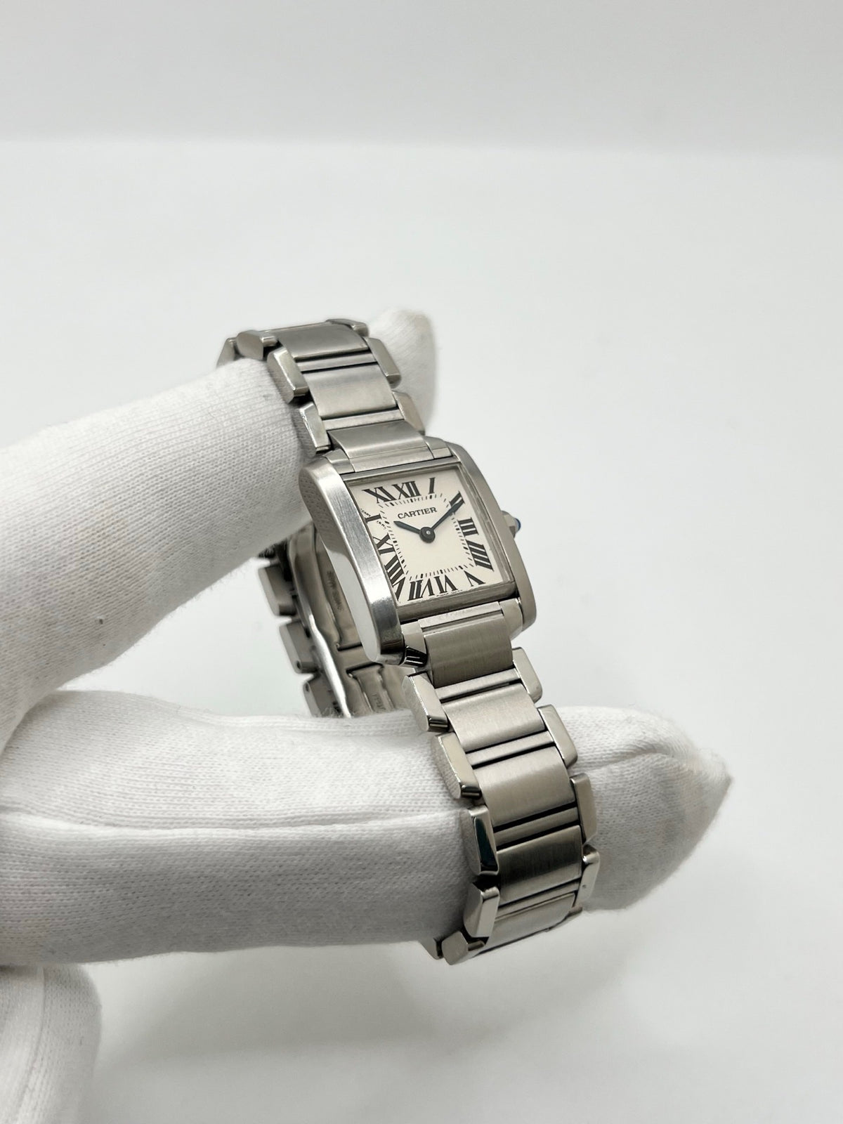 Montre Cartier Tank Française 2384 pour femme, dotée d’un mouvement à quartz et d’un boîtier rectangulaire en acier de 20 × 25 mm. Son cadran blanc est protégé par un verre saphir, tandis que son bracelet en acier avec boucle déployante double apporte une finition élégante et raffinée. D’une hauteur de 6 mm et étanche à 3 ATM, cette Cartier Tank Française incarne le style intemporel de la Maison. Modèle en très bon état, vendu avec son coffret d’origine.