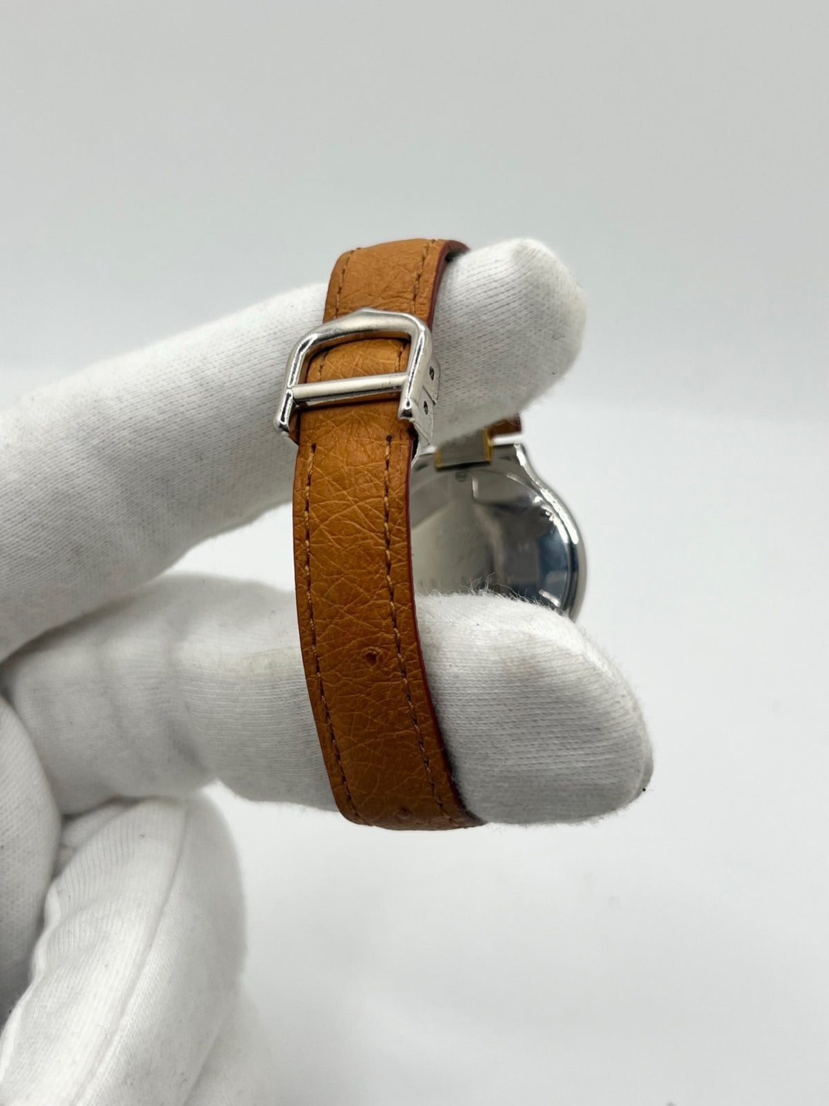 Montre Cartier 21 Must de Cartier 9011 pour femme, équipée d’un mouvement quartz et d’un boîtier en acier de 28 mm. Son cadran blanc offre une esthétique élégante et intemporelle. Cette montre Cartier est montée sur un bracelet brun en cuir avec boucle déployante à plis. En bon état, elle présente des traces d’usure visibles et perceptibles, notamment quelques rayures, éraflures et petites bosses. Révisée en interne en septembre 2026.

