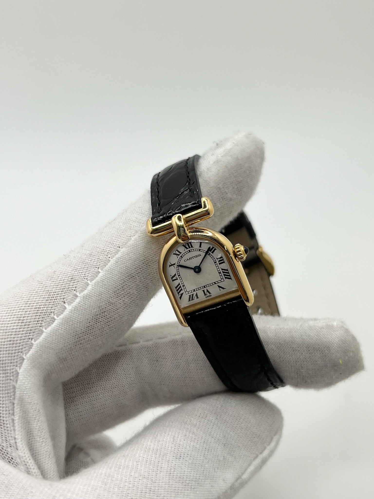 Montre Cartier modèle Calandre pour femme élégante en or jaune avec boîtier rectangulaire de 18 x 26 mm, lignes raffinées et design iconique des années 1980. Cadran blanc lumineux orné de chiffres romains noirs, protégé par un verre minéral. Mouvement à quartz assurant une lecture précise de l’heure. Bracelet en cuir de crocodile noir apportant une touche sophistiquée, équipé d’une boucle ardillon en acier. Modèle vintage en très bon état, présentant de légères micro-rayures superficielles liées à l’âge.