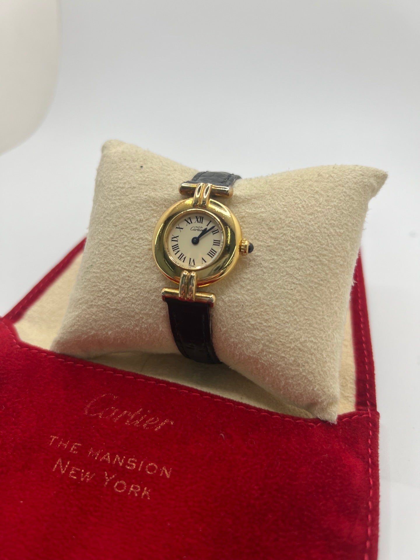 Montre Cartier Colisée Must Vermeil réf. 590002 pour femme, équipée d’un mouvement quartz précis. Boîtier en argent vermeil de 24 mm, cadran blanc à chiffres romains, verre saphir et bracelet en cuir noir avec boucle ardillon. Modèle d’occasion en bon état présentant quelques traces d’usure. Idéal pour les amateurs de montres élégantes et intemporelles.