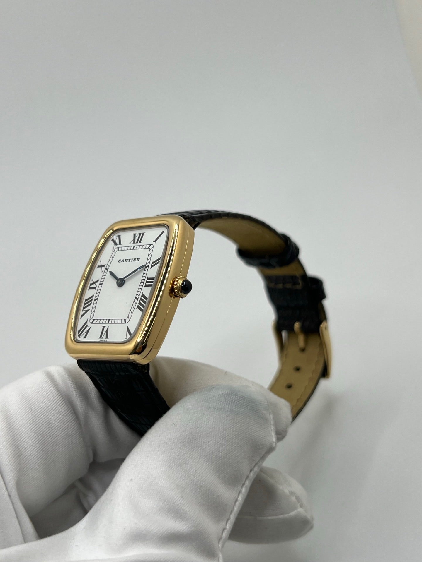 Montre Cartier Fabergé vintage en or jaune avec boîtier rectangulaire de 26 mm, cadran blanc à chiffres romains et bracelet en cuir noir. Ce modèle élégant à remontage manuel, fabriqué vers 1970, séduit par son style intemporel et raffiné. Montre homme ou unisexe d’occasion en très bon état, livrée avec coffret d’origine, idéale pour les amateurs d’horlogerie de luxe et de pièces vintage authentiques.