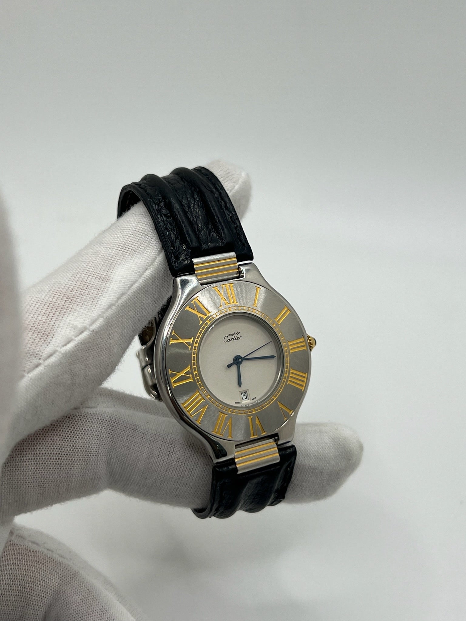 Montre Cartier 21 Must de Cartier avec boîtier 35 mm en or et acier, cadran blanc à chiffres romains, mouvement quartz. Modèle élégant et mixte, équipé d’une boucle déployante sur bracelet cuir noir. Montre de luxe vintage en très bon état, révisée, disponible sans boîte ni papiers d’origine. Idéale pour collectionneur ou amateur de montres emblématiques signées Cartier.