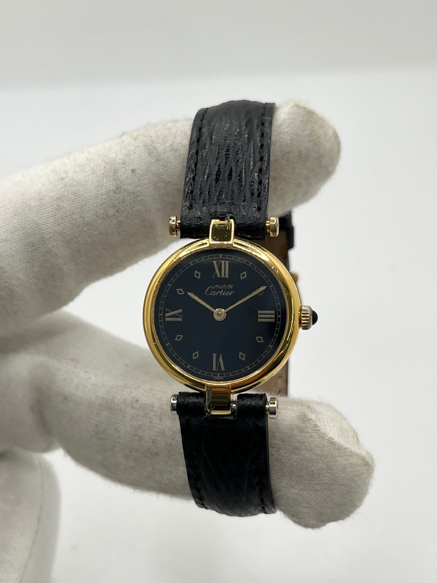 Cartier Must Vendôme référence 590004 en argent avec boîtier de 24 mm, cadran noir à chiffres romains et mouvement à quartz. Cette montre femme est équipée d'un bracelet en cuir, d'une boucle ardillon en acier et d'un verre saphir. Modèle d'occasion en très bon état, révisé en interne en 2026. Une montre Cartier vintage au design élégant, idéale pour les amateurs d'horlogerie de luxe et de pièces intemporelles.
