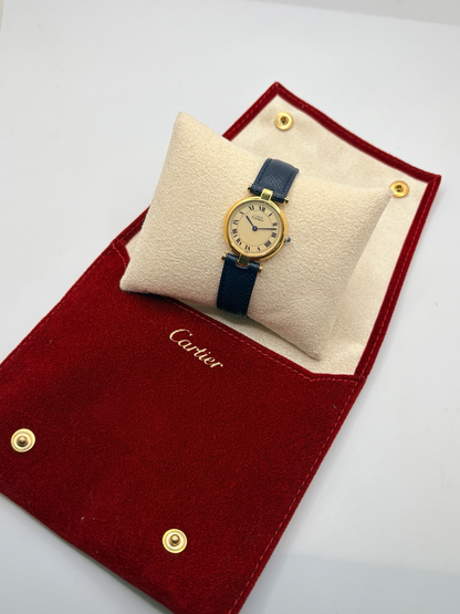 Montre Cartier Must Vendôme PM pour femme, équipée d’un mouvement à quartz et présentée dans un boîtier en argent de 24 mm. Son cadran blanc à chiffres romains est protégé par un verre saphir. Cette montre Cartier est montée sur un bracelet en cuir bleu avec boucle ardillon en acier. Élégante et intemporelle, la Cartier Must Vendôme PM séduit par son format compact, son design raffiné et son style emblématique, idéale au quotidien ou pour une occasion spéciale.
