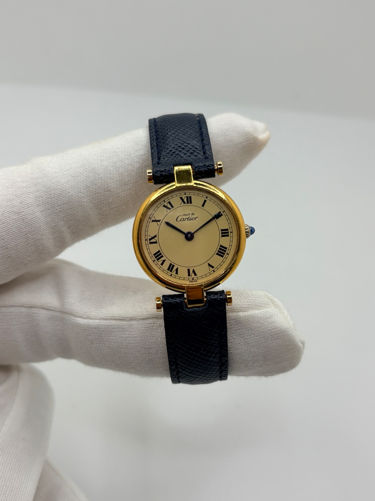 Montre Cartier Must Vendôme PM pour femme, équipée d’un mouvement à quartz et présentée dans un boîtier en argent de 24 mm. Son cadran blanc à chiffres romains est protégé par un verre saphir. Cette montre Cartier est montée sur un bracelet en cuir bleu avec boucle ardillon en acier. Élégante et intemporelle, la Cartier Must Vendôme PM séduit par son format compact, son design raffiné et son style emblématique, idéale au quotidien ou pour une occasion spéciale.