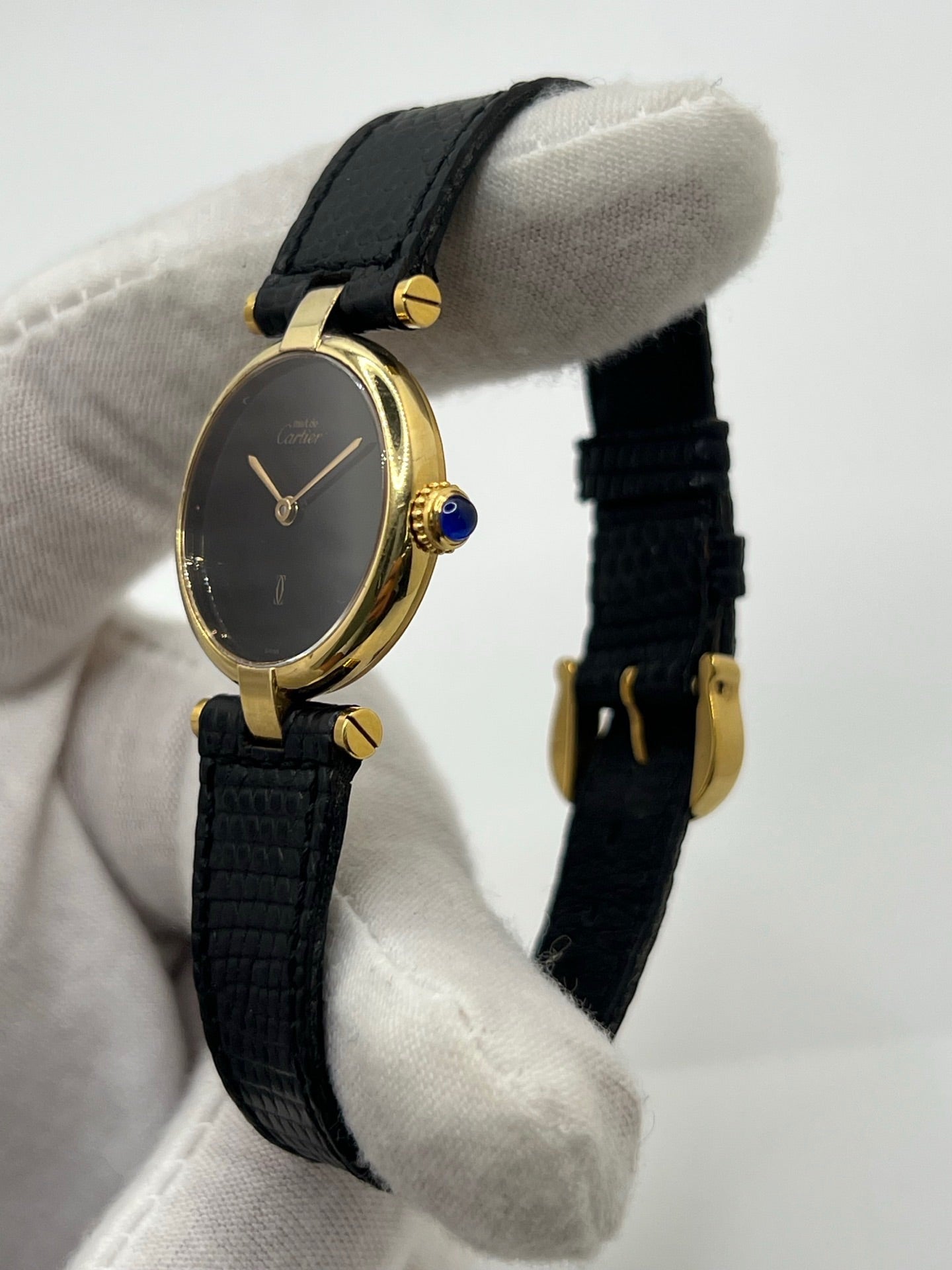 Montre Cartier Must de Cartier Vendome pour femme, boîtier argent de 24 mm avec cadran noir sans chiffres, mouvement quartz précis, verre saphir résistant aux rayures, bracelet cuir noir avec boucle ardillon en acier. État d’occasion très bon, livrée avec coffret d’origine. Élégante et intemporelle, idéale pour collection ou usage quotidien.