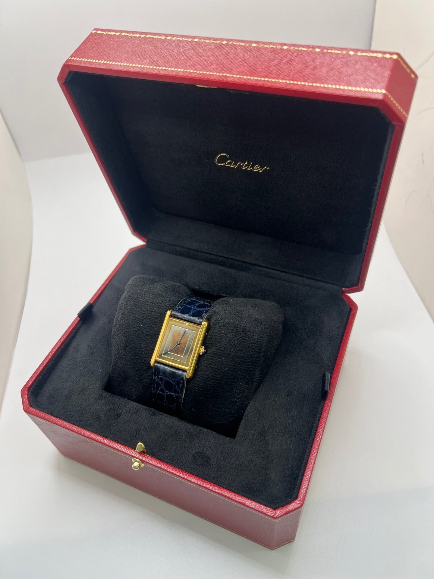 Montre Cartier Must de Cartier Tank Trinity en argent, à remontage manuel, avec boîtier de 23 x 30 mm et cadran jaune sans chiffres. Ce modèle emblématique est équipé d’un bracelet en cuir bleu avec boucle ardillon en acier, d’un verre minéral et d’une lunette en argent. Montre de luxe vintage homme ou unisexe, d’occasion en bon état, présentant des traces d’usure visibles. Révisée en interne, livrée avec coffret d’origine, idéale pour les collectionneurs de montres Cartier Tank Trinity.