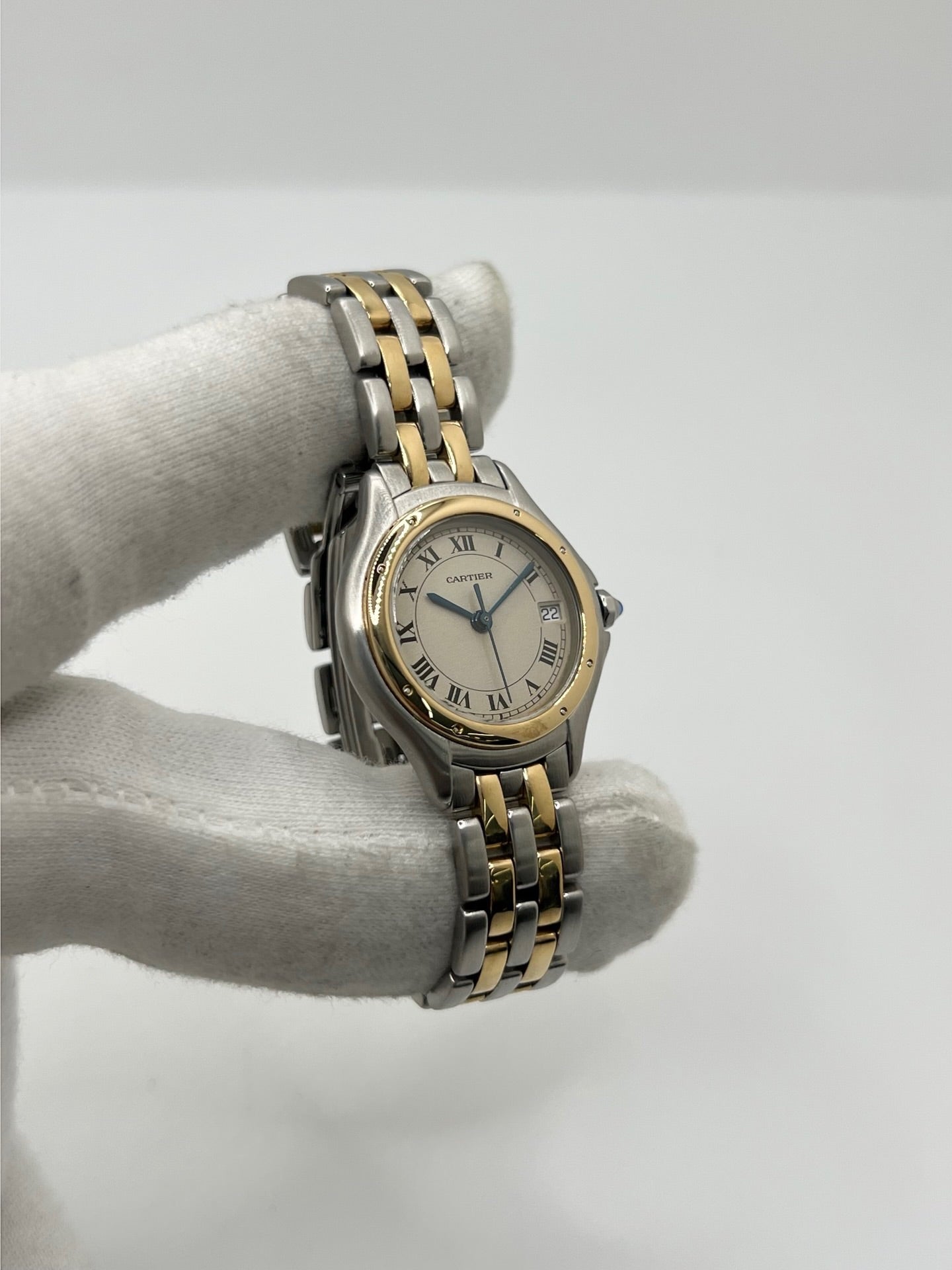 Montre Cartier Panthère référence 119000R pour femme en or jaune et acier, équipée d'un mouvement à quartz. Son boîtier de 26 mm est sublimé par une lunette en or jaune, un cadran blanc à chiffres romains et un verre saphir résistant aux rayures. Son bracelet bicolore en or et acier avec boucle déployante assure un porté confortable. Cette montre d'occasion est en très bon état, révisée en interne et livrée avec son coffret d'origine.