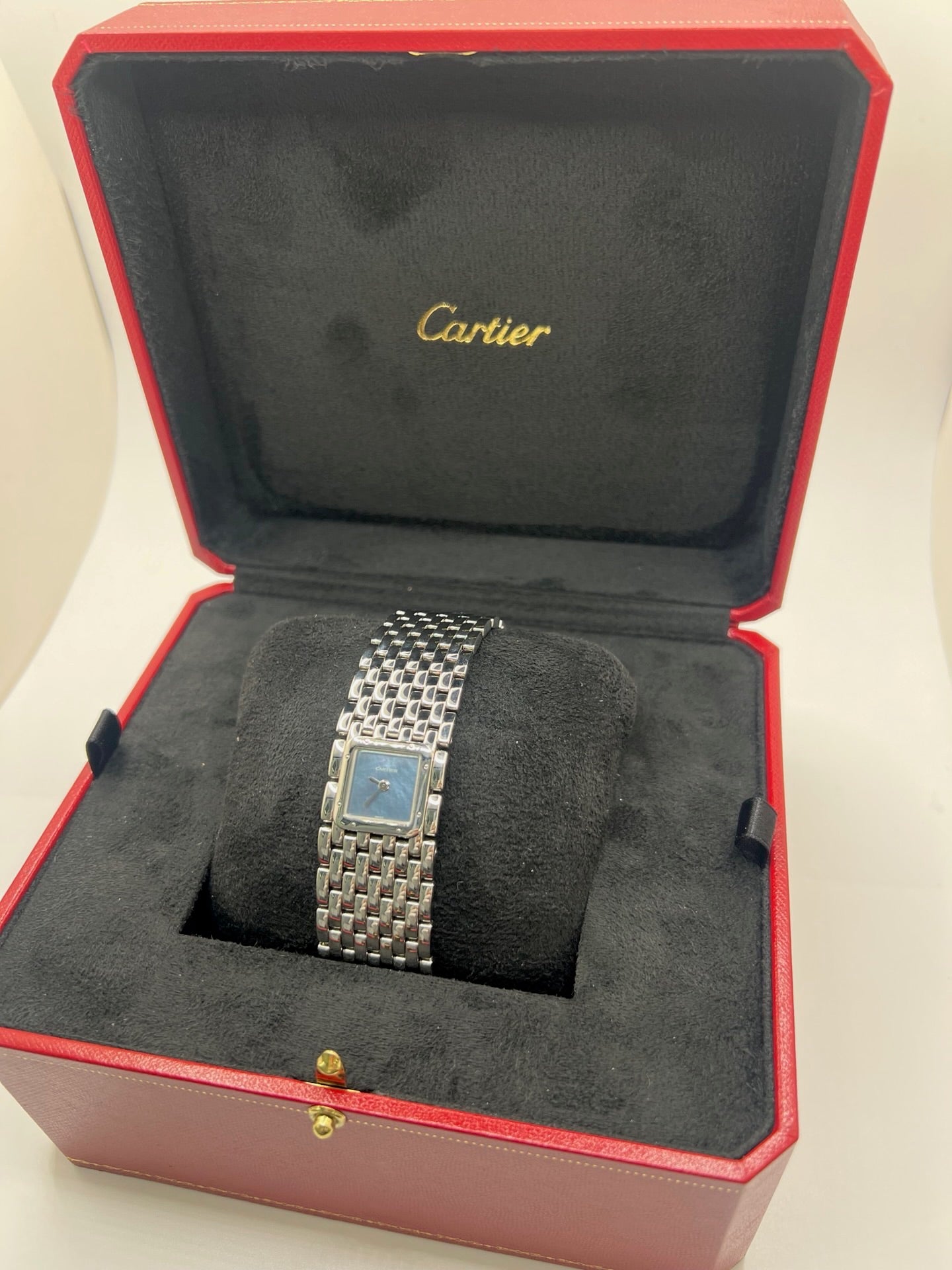 Montre femme de la maison Cartier, modèle Panthère Ruban réf. 2420, en acier avec boîtier de 21 mm et lunette assortie, verre saphir, cadran en nacre aux chiffres romains, mouvement quartz précis, bracelet acier avec boucle double plis. Étanchéité 3 ATM. D’occasion en très bon état, livrée avec coffret d’origine, élégante et intemporelle pour un style raffiné au quotidien ou en occasion spéciale.
