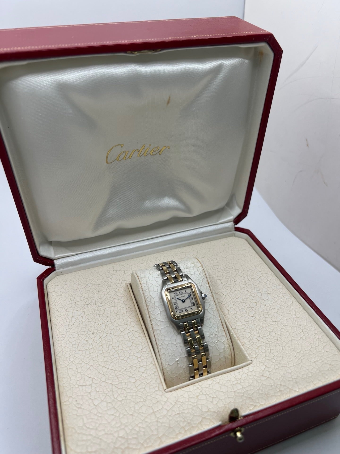 Montre Cartier Panthère 166921 pour femme en or et acier, équipée d’un mouvement quartz suisse. Ce modèle iconique présente un boîtier de 22 x 21 mm, une lunette en or jaune, un cadran blanc à chiffres romains et un verre saphir. Son bracelet en or et acier avec boucle double plis complète son élégance intemporelle. Montre de luxe d’occasion en très bon état, révisée, avec coffret d’origine, idéale pour les amateurs de montres Cartier Panthère femme.