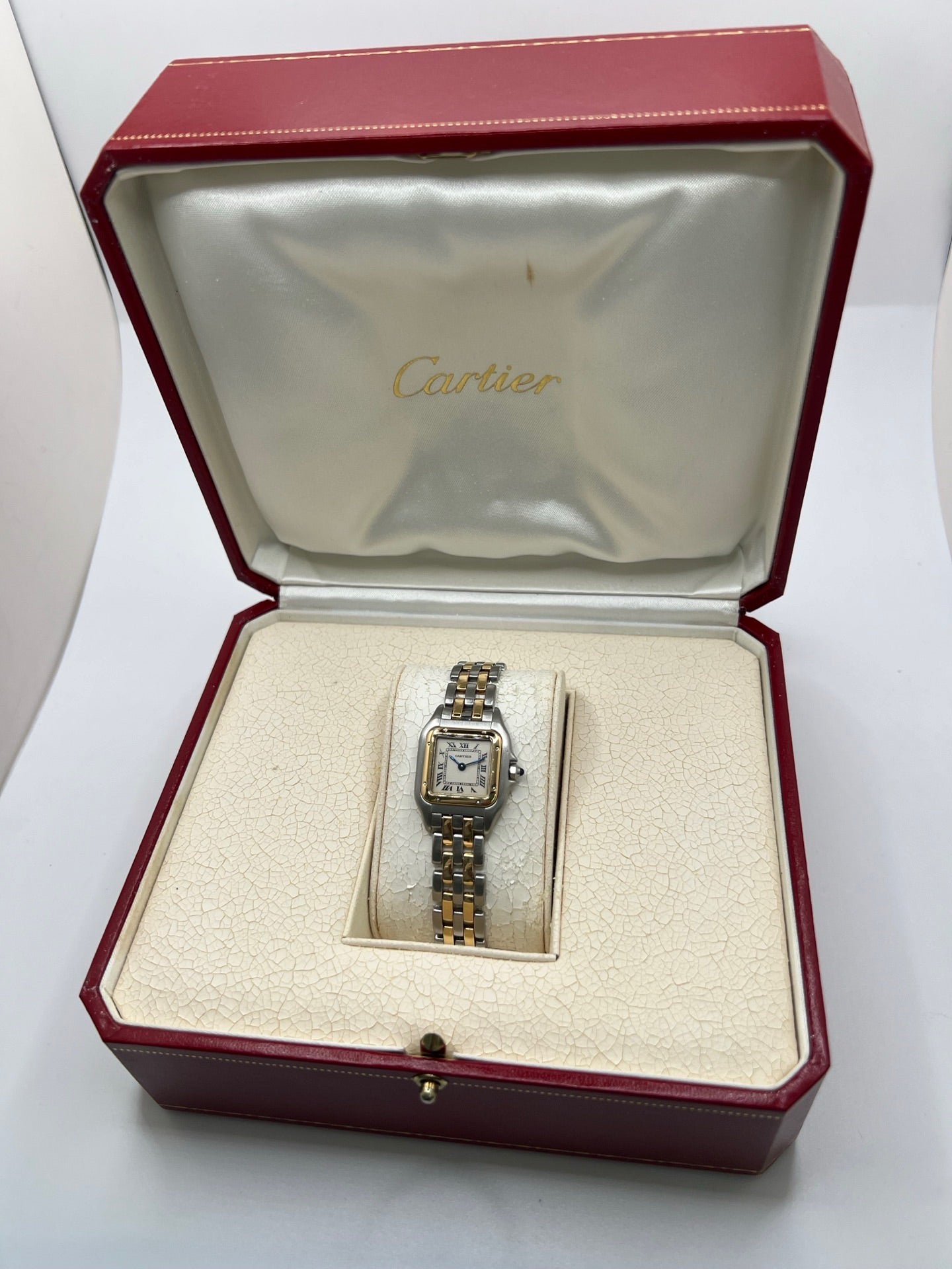 Montre Cartier Panthère 166921 pour femme en or et acier, équipée d’un mouvement quartz suisse. Ce modèle iconique présente un boîtier de 22 x 21 mm, une lunette en or jaune, un cadran blanc à chiffres romains et un verre saphir. Son bracelet en or et acier avec boucle double plis complète son élégance intemporelle. Montre de luxe d’occasion en très bon état, révisée, avec coffret d’origine, idéale pour les amateurs de montres Cartier Panthère femme.