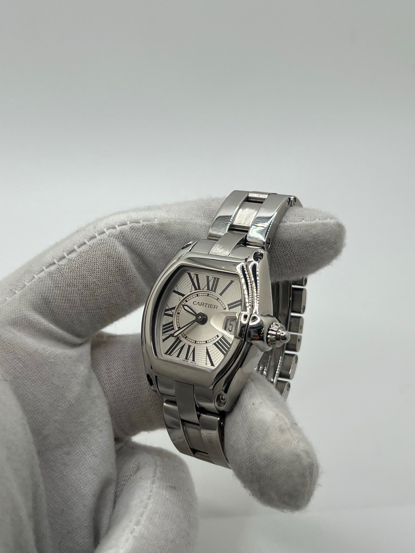 Montre Cartier Roadster 2675 pour femme en acier, équipée d’un mouvement quartz calibre 688. Boîtier 31 x 37 mm avec verre saphir, cadran argent à chiffres romains et bracelet acier à boucle déployante. Modèle étanche à 10 ATM avec fonction date, livré avec coffret d’origine, en très bon état d’occasion.