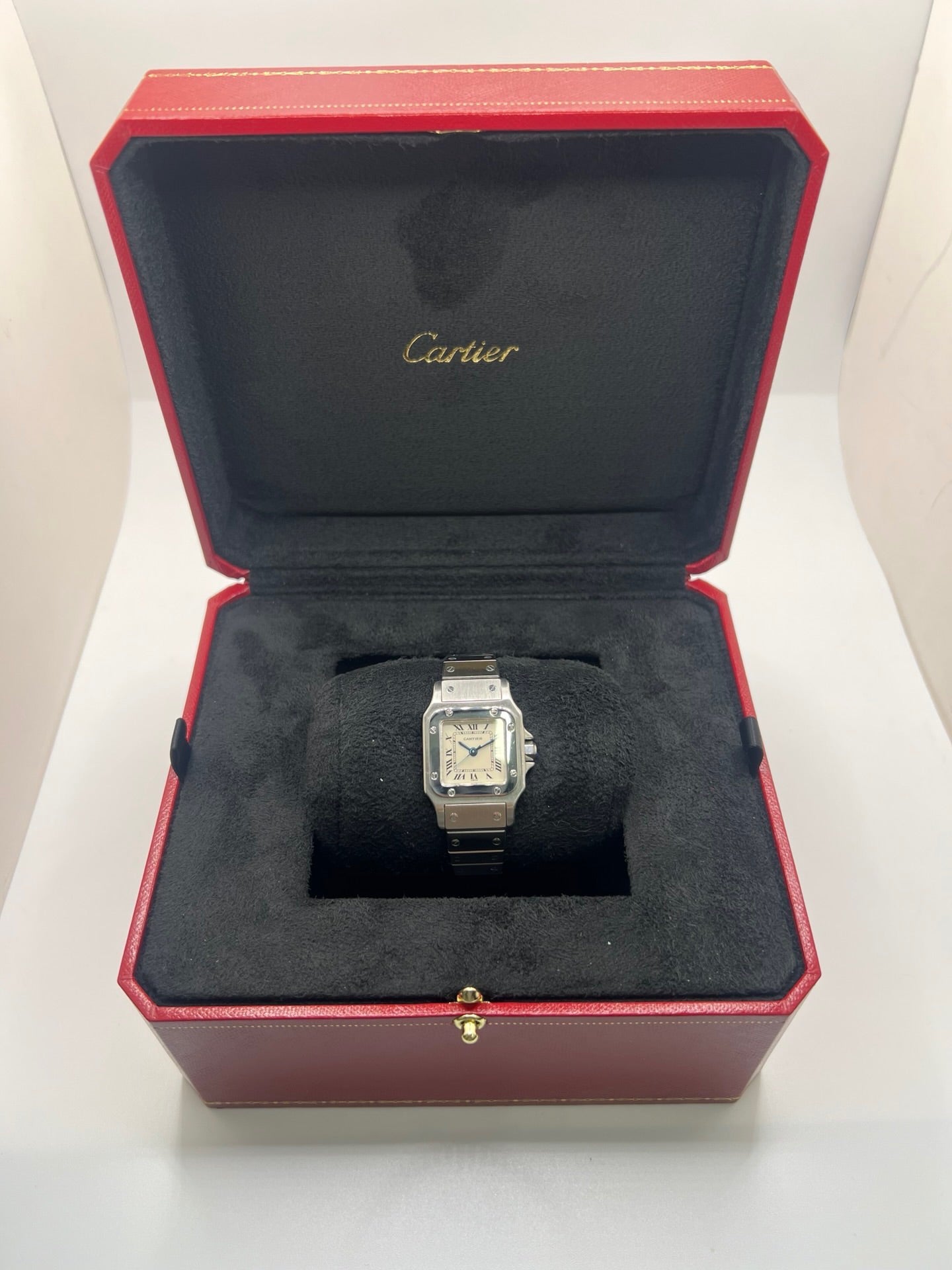 Montre Cartier Santos Lady en acier pour femme, modèle vintage à remontage automatique avec cadran blanc à chiffres romains, boîtier rectangulaire 24 x 35 mm, verre saphir et bracelet acier. Cette montre d’occasion en très bon état présente de légères traces d’usure discrètes. Livrée avec son coffret d’origine, sans papiers, cette Cartier Santos Lady allie élégance intemporelle, raffinement horloger et style iconique pour une collection de montres de luxe femme.