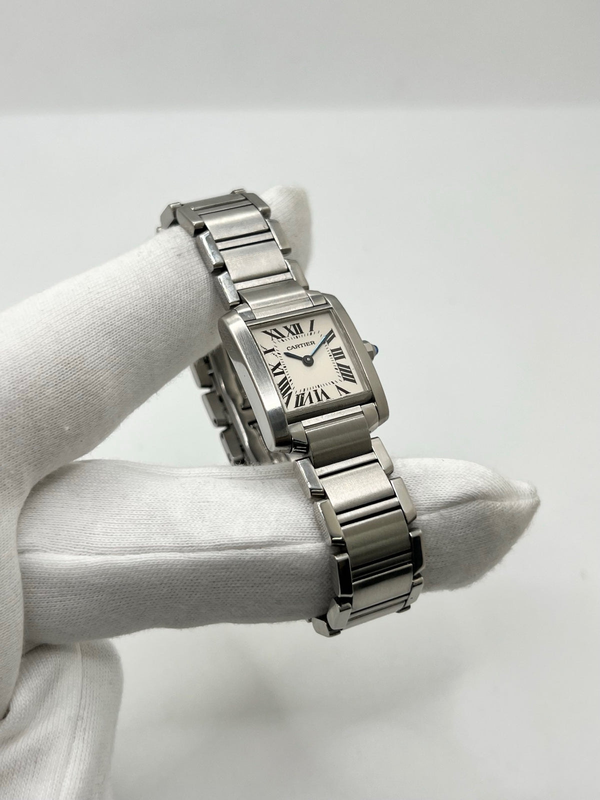 Montre Cartier Tank Française 2384 pour femme, dotée d’un mouvement à quartz et d’un boîtier rectangulaire en acier de 20 × 25 mm. Son cadran blanc est protégé par un verre saphir, tandis que son bracelet en acier avec boucle déployante double apporte une finition élégante et raffinée. D’une hauteur de 6 mm et étanche à 3 ATM, cette Cartier Tank Française incarne le style intemporel de la Maison. Modèle en très bon état, vendu avec son coffret d’origine.