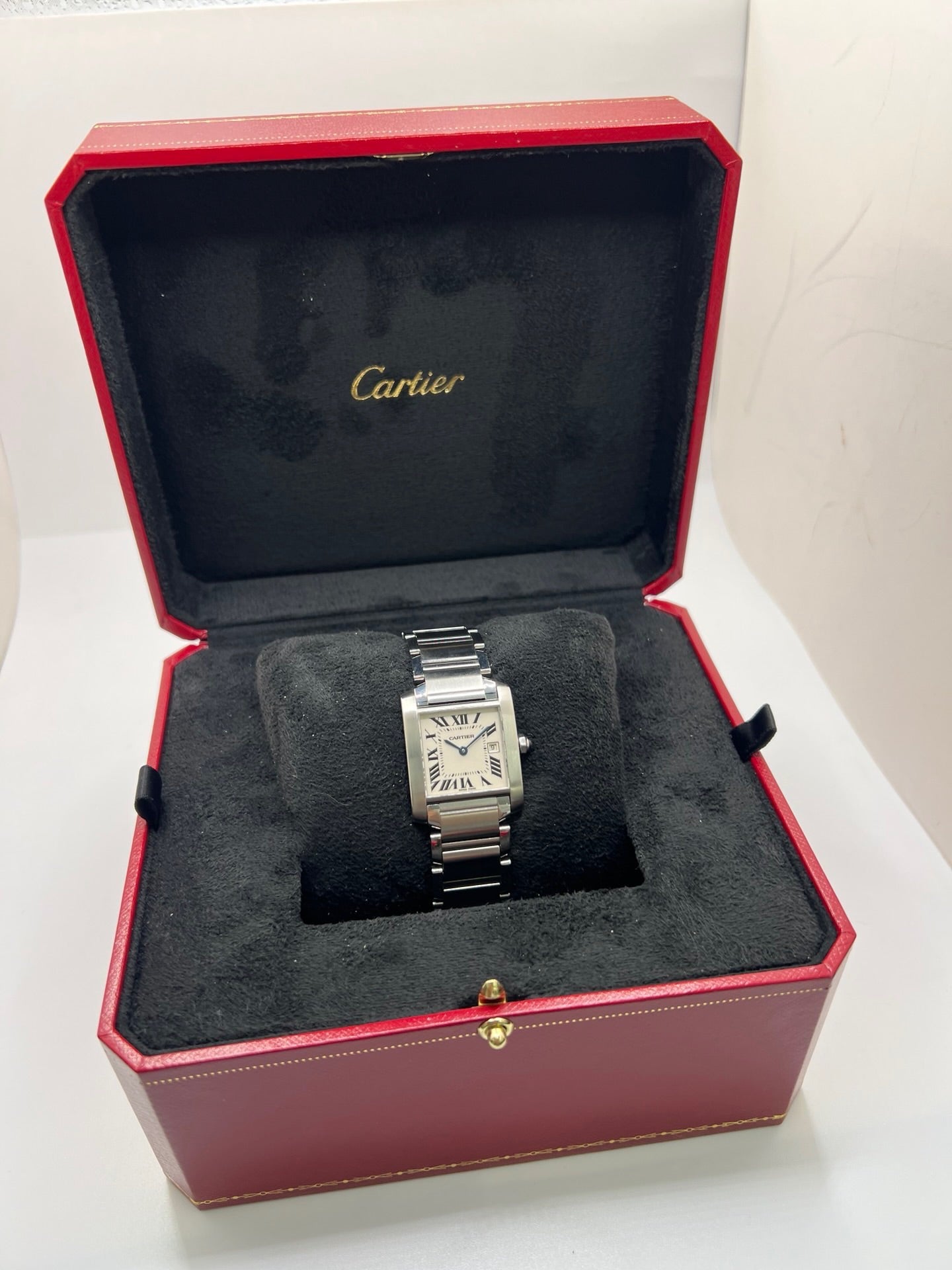 Montre Cartier Tank Française 2465 pour femme en acier, dotée d’un mouvement quartz et d’un cadran blanc à chiffres romains. Ce modèle iconique présente un boîtier de 25 x 30 mm, un bracelet en acier avec boucle double plis, ainsi qu’un verre saphir. Montre de luxe d’occasion en très bon état, avec de légères traces d’usure discrètes. Livrée avec son coffret d’origine, sans papiers, révisée en interne en mars 2026.