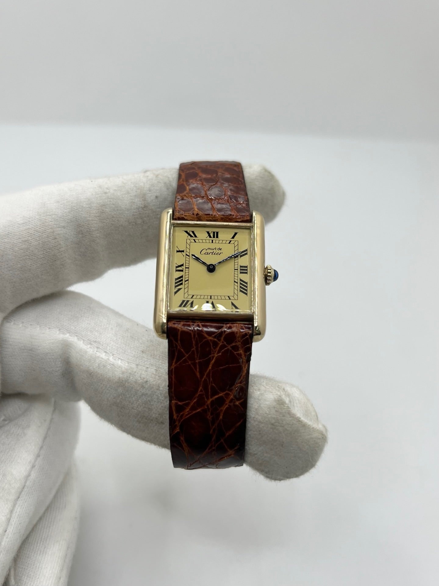 Cartier Tank Must Vermeil en argent avec boîtier rectangulaire de 23 x 30 mm, mouvement à remontage manuel et cadran champagne à chiffres romains. Cette montre unisexe est équipée d’un bracelet en cuir brun avec boucle ardillon en acier et d’un verre saphir. Modèle d’occasion en très bon état, révisé en interne en 2026. Une montre Cartier élégante et intemporelle, livrée avec coffret d’origine, sans papiers d’origine.

