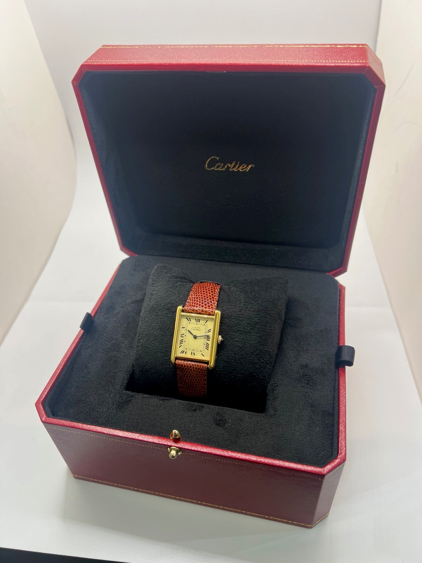 Montre Cartier Tank Must Vermeil, boîtier argent 31 x 23 mm, mouvement à remontage manuel Cartier 78-1 avec réserve de marche de 44 h et 17 pierres. Cadran blanc à chiffres romains, verre minéral. Bracelet en cuir de lézard brun avec boucle en argent. État d’occasion très bon avec légères rayures, alliant élégance intemporelle et design iconique pour homme ou unisexe.
