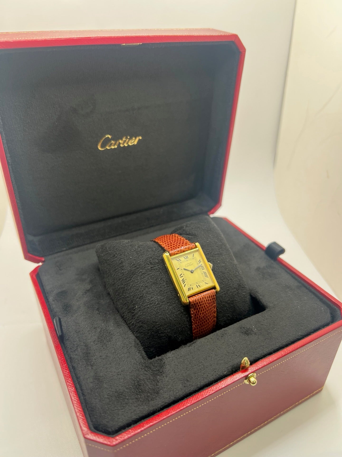Montre Cartier Tank Must Vermeil, boîtier argent 31 x 23 mm, mouvement à remontage manuel Cartier 78-1 avec réserve de marche de 44 h et 17 pierres. Cadran blanc à chiffres romains, verre minéral. Bracelet en cuir de lézard brun avec boucle en argent. État d’occasion très bon avec légères rayures, alliant élégance intemporelle et design iconique pour homme ou unisexe.