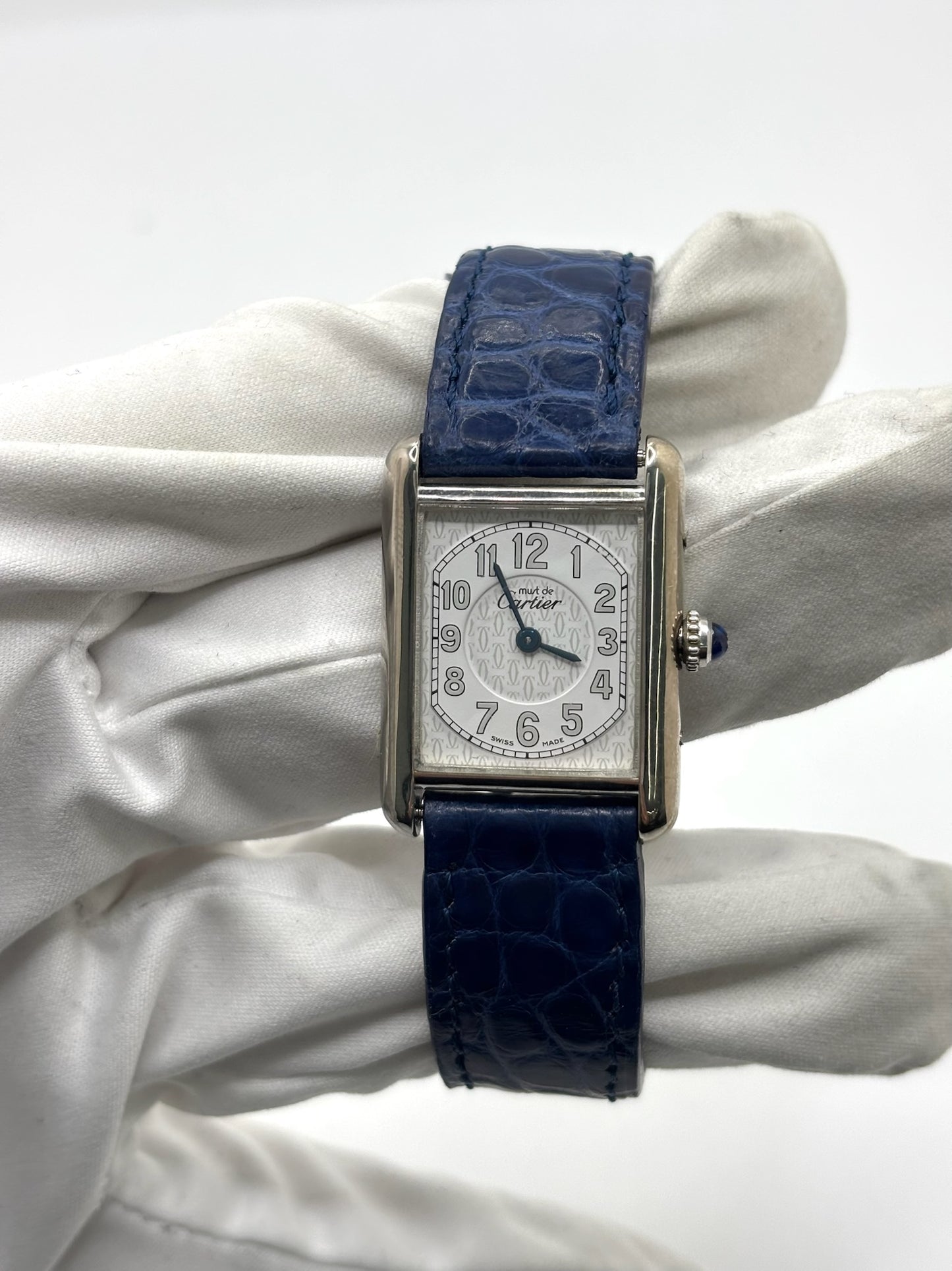 Montre Cartier Tank Must référence 2416 en argent avec cadran blanc à chiffres arabes et mouvement quartz. Ce modèle iconique présente un boîtier rectangulaire de 22 x 30 mm, une lunette en argent et un bracelet en cuir bleu avec boucle ardillon en acier. Cartier Tank Must d'occasion en très bon état, avec de légères traces d'usure. Montre homme ou unisexe élégante et intemporelle, idéale pour les amateurs d'horlogerie et de montres de luxe vintage.
