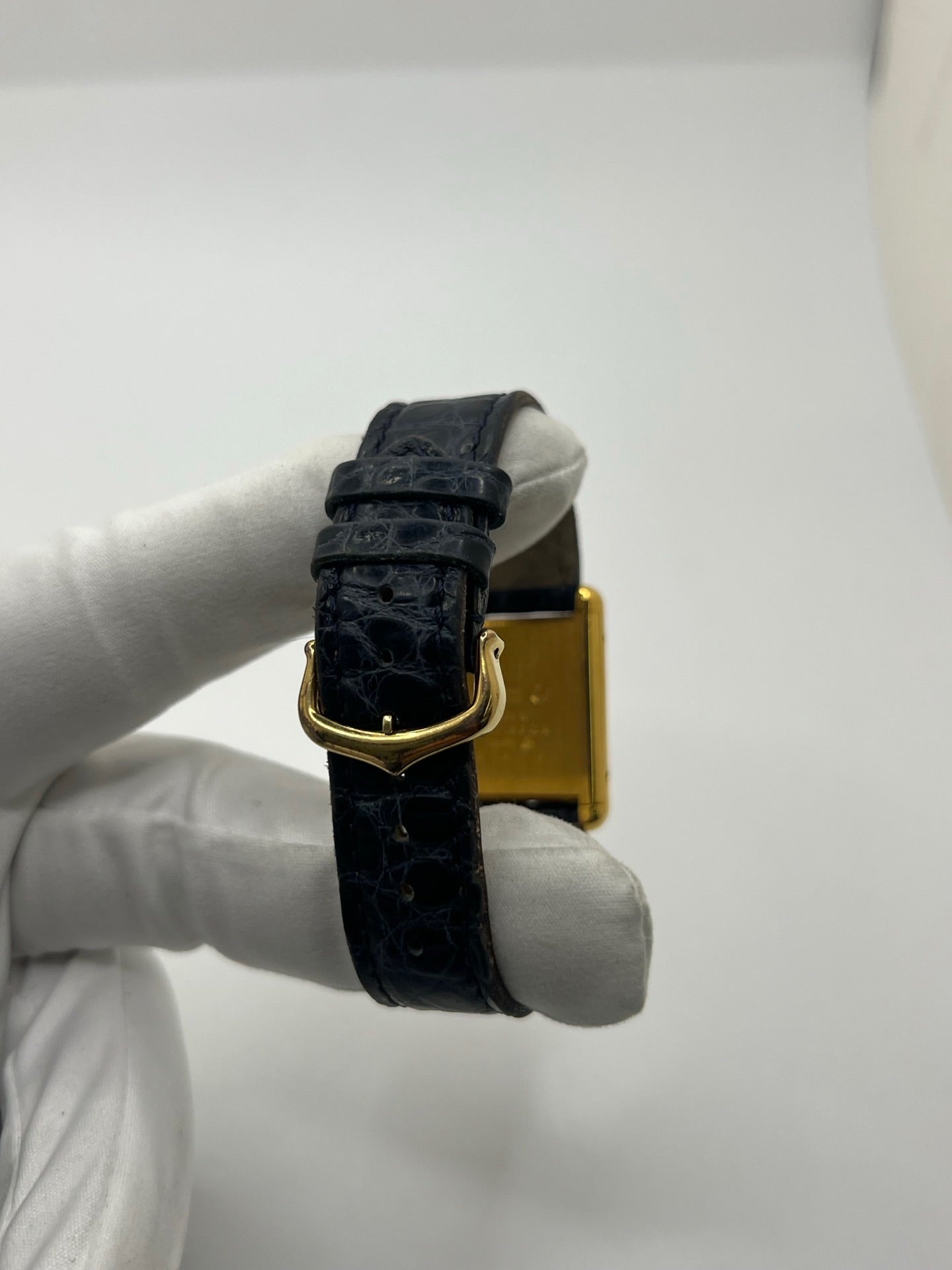 Montre Cartier Must de Cartier Tank Trinity en argent, à remontage manuel, avec boîtier de 23 x 30 mm et cadran jaune sans chiffres. Ce modèle emblématique est équipé d’un bracelet en cuir bleu avec boucle ardillon en acier, d’un verre minéral et d’une lunette en argent. Montre de luxe vintage homme ou unisexe, d’occasion en bon état, présentant des traces d’usure visibles. Révisée en interne, livrée avec coffret d’origine, idéale pour les collectionneurs de montres Cartier Tank Trinity.