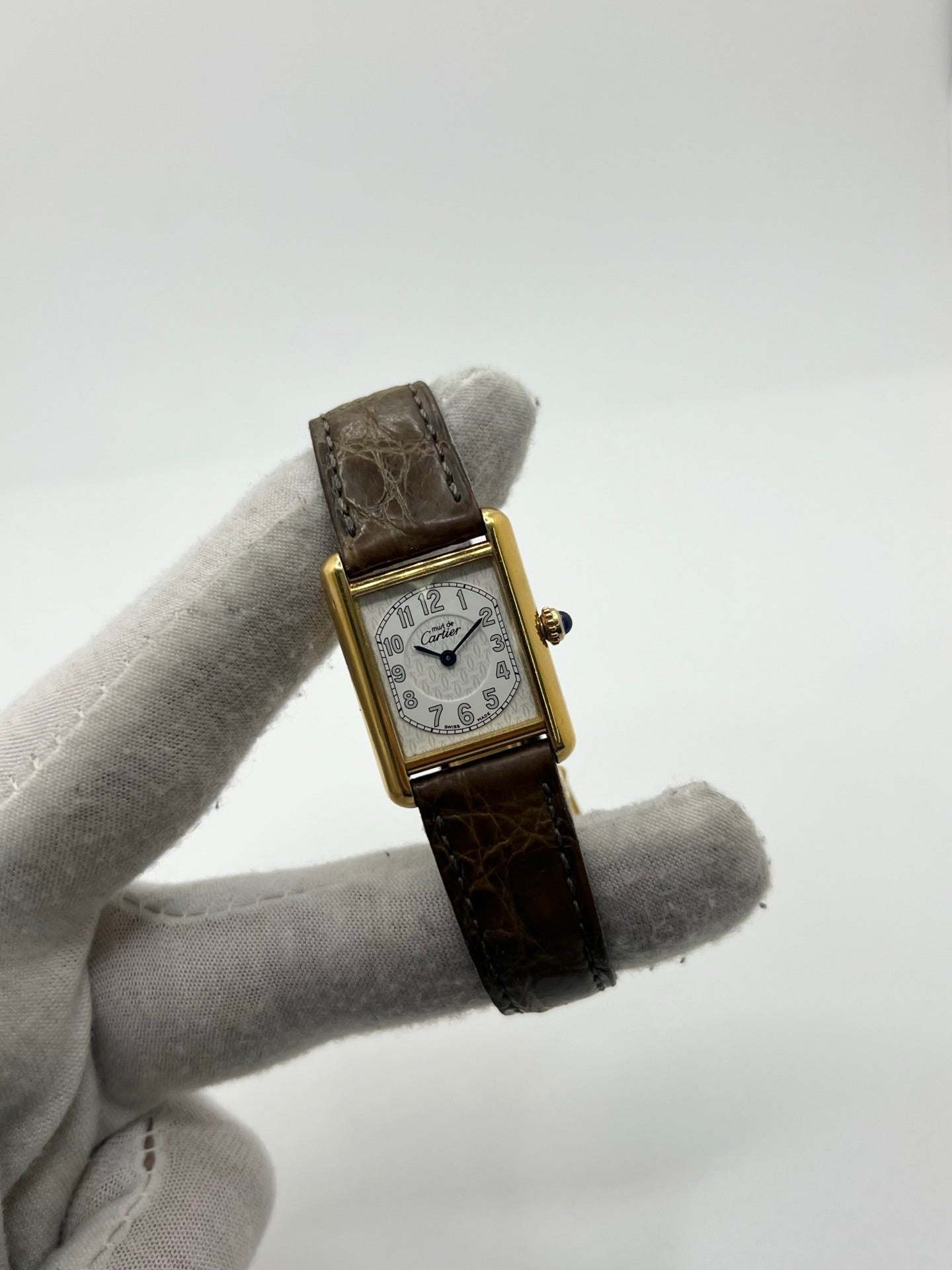 Montre Cartier Tank Vermeil 2415 pour femme, équipée d’un mouvement quartz et d’un boîtier en argent de 22 x 29 mm. Ce modèle d’occasion en bon état présente des traces d’usure visibles, un cadran blanc à chiffres arabes, un verre minéral et un bracelet en cuir brun avec boucle ardillon en argent. Élégante et classique, la Cartier Tank Vermeil 2415 séduit par son design intemporel, idéale pour les passionnées de montres de luxe.