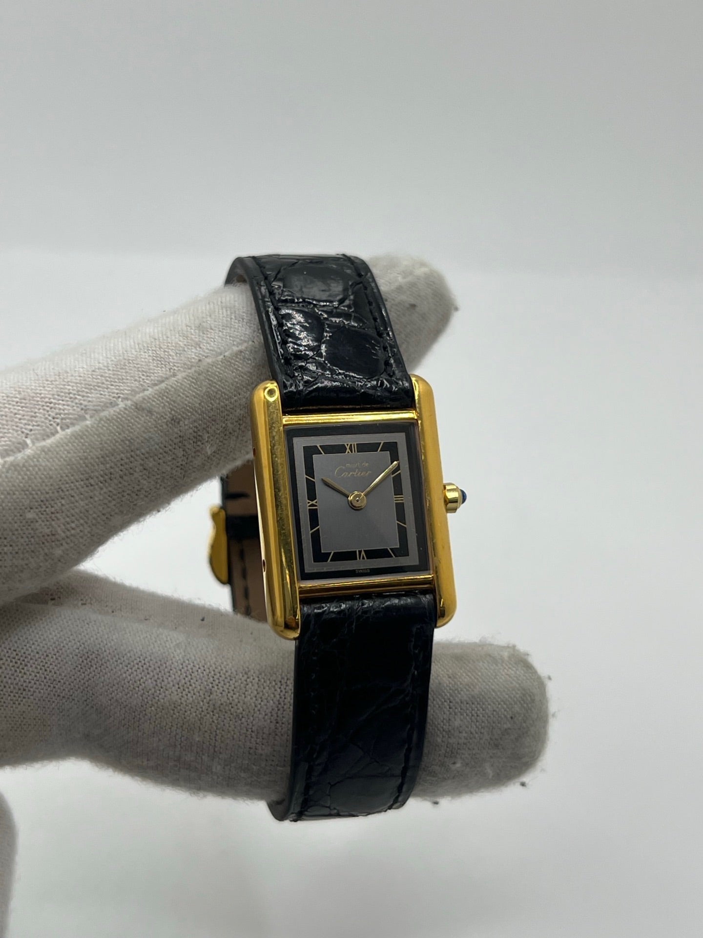 Montre Cartier Tank Vermeil 3 66001 pour femme, équipée d’un mouvement quartz et d’un boîtier en argent de 20 x 27 mm. Ce modèle d’occasion en très bon état présente un cadran or à chiffres romains, un verre minéral et un bracelet en cuir de crocodile noir avec boucle en acier. Élégante et intemporelle, la Cartier Tank Vermeil 3 66001 séduit par son design classique, idéale pour les passionnées de montres de luxe raffinées.