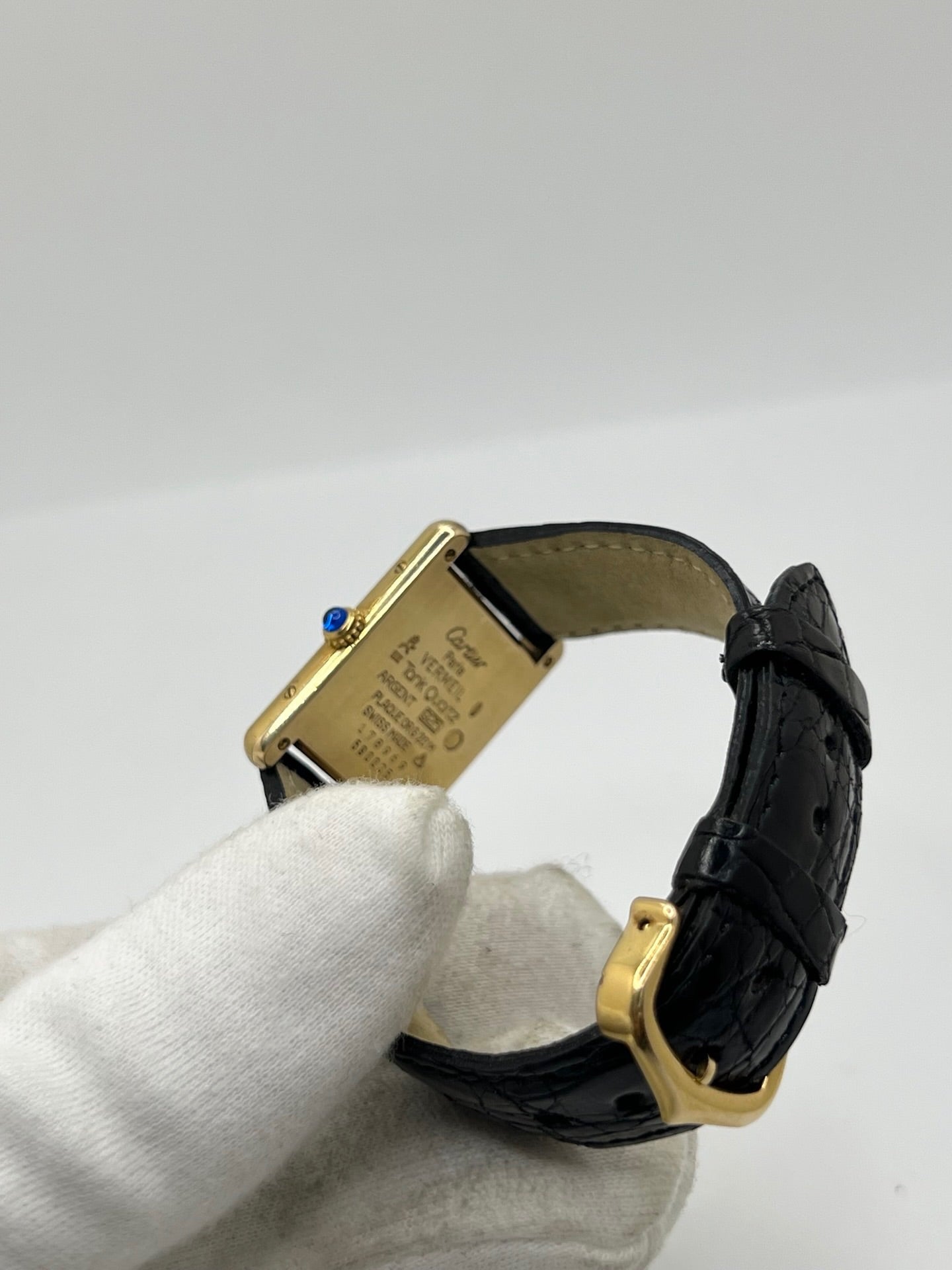 Montre Cartier Tank Vermeil réf. 590005 en argent avec mouvement à quartz, cadran champagne à chiffres romains et verre saphir. Ce modèle emblématique est monté sur un bracelet en cuir de crocodile noir avec boucle ardillon en acier. Son boîtier de 23 × 30 mm offre une élégance intemporelle. Cette montre Cartier Tank Vermeil d'occasion est en très bon état, révisée en interne et livrée avec son coffret d'origine.